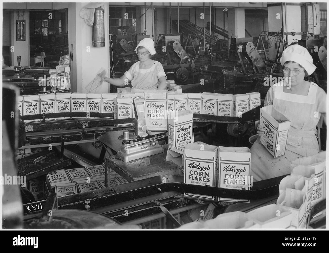 Frauen in der Produktionslinie der Kellogg Company inspizieren gefüllte Getreideboxen, bevor die Kisten an die Schließeinrichtung in Battle Creek, Michigan, am 22.08.1934. (Foto: Women's Bureau/National Archives and Records Administration) Stockfoto
