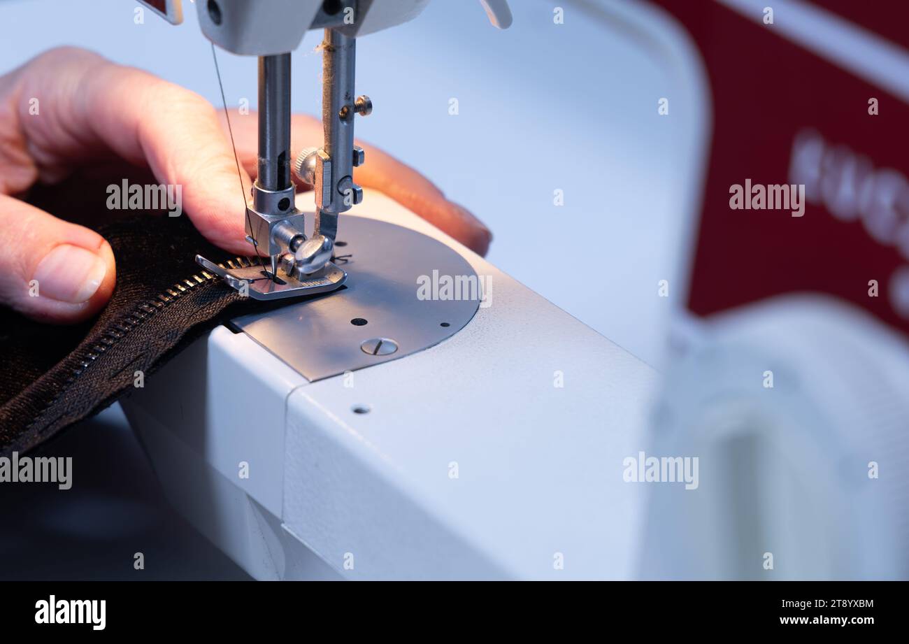 Nähmaschine zu Hause in einer Schneiderei, alte Kleidung reparieren Stockfoto