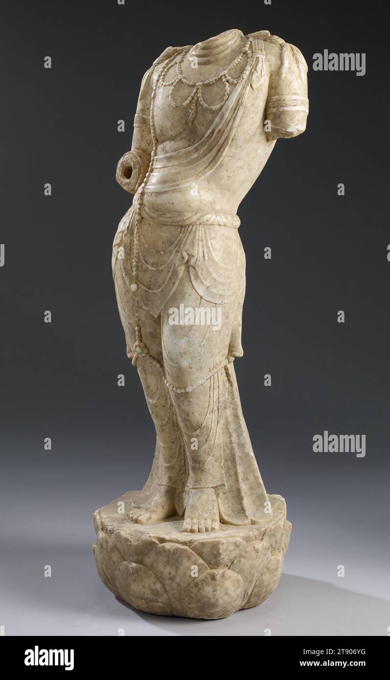 Bodhisattva, Ende des 7. Bis Anfang des 8. Jahrhunderts, 32 x 12 1/2 x 11 1/2 cm (81,28 x 31,75 x 29,21 cm), Marmor, China, 7. Bis 8. Jahrhundert, obwohl es Kopf und Arme fehlt, veranschaulicht dieses Werk die anmutige Figurenbewegung, die in der Skulptur der Tang-Dynastie gefunden wurde, wie sie sich in den späten 600er Jahren entwickelt hatte Es ist ein klassisches Beispiel für die Art der realistischen Darstellung, die stark von der skulpturalen Kunst Indiens während der Gupta-Zeit (320–647) beeinflusst wurde. Die gut proportionierte Figur in schwacher Pose ist mit leichten, fast durchsichtigen mehrschichtigen Gewändern bedeckt, die sich von der linken Schulter bis zum Lotus erstrecken Stockfoto