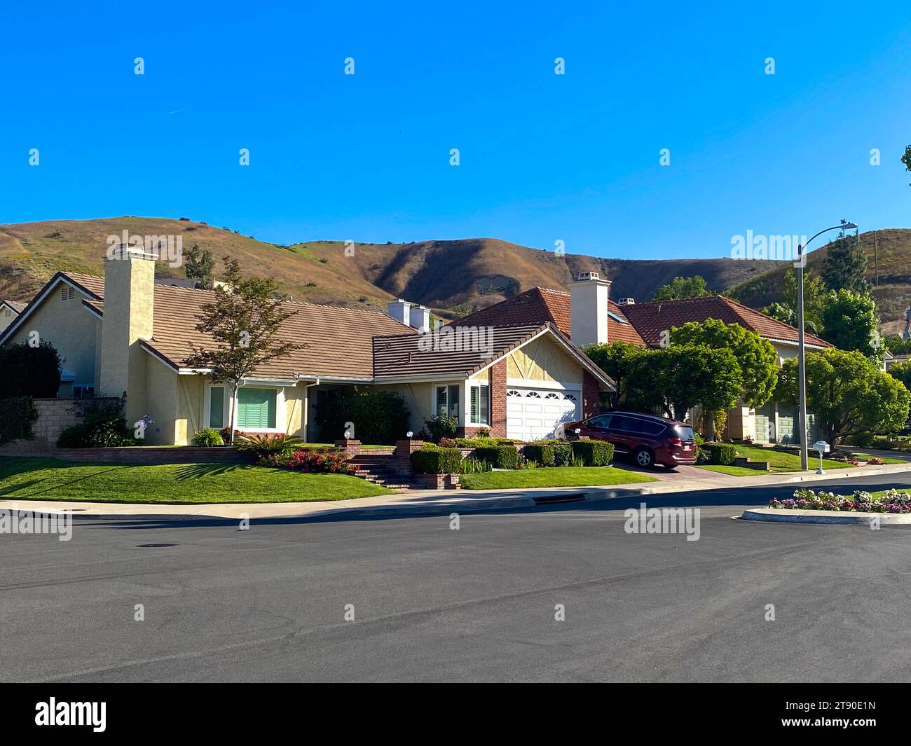 Eine Straße mit Häusern und einem Auto am Straßenrand. Stockfoto