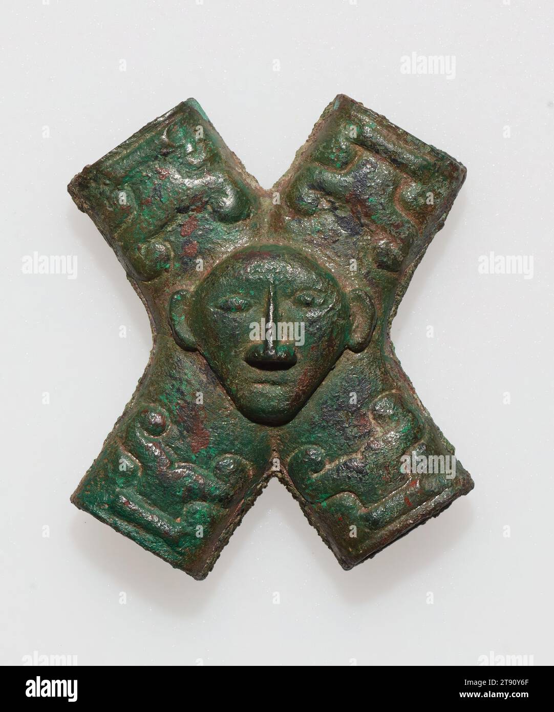 Kreuzrohr mit menschlicher Kopfmaske, 10.-9. Jahrhundert v. Chr., H.2-1/16 x B 1-3/4 x T 7/16 cm, Bronze, China, 10.-9. Jahrhundert v. Chr., das menschliche Gesicht wird selten als Motiv in frühen chinesischen Bronzen verwendet. Diese kleine Armatur weist außerdem vier vereinfachte t'ao-t'ieh-Masken mit abgerundetem Relief am Ende jedes Rohrs auf. Das Objekt diente am ehesten dazu, die Lederbänder eines Pferdezuges zu verbinden. Die Internierung von Pferden in königlichen und aristokratischen bronzezeitlichen Gräbern war im alten China relativ häufig, und eine große Anzahl von bronzenen Wagen- und Gurtbeschlägen wurde aus solchen Begräbnissen gewonnen Stockfoto