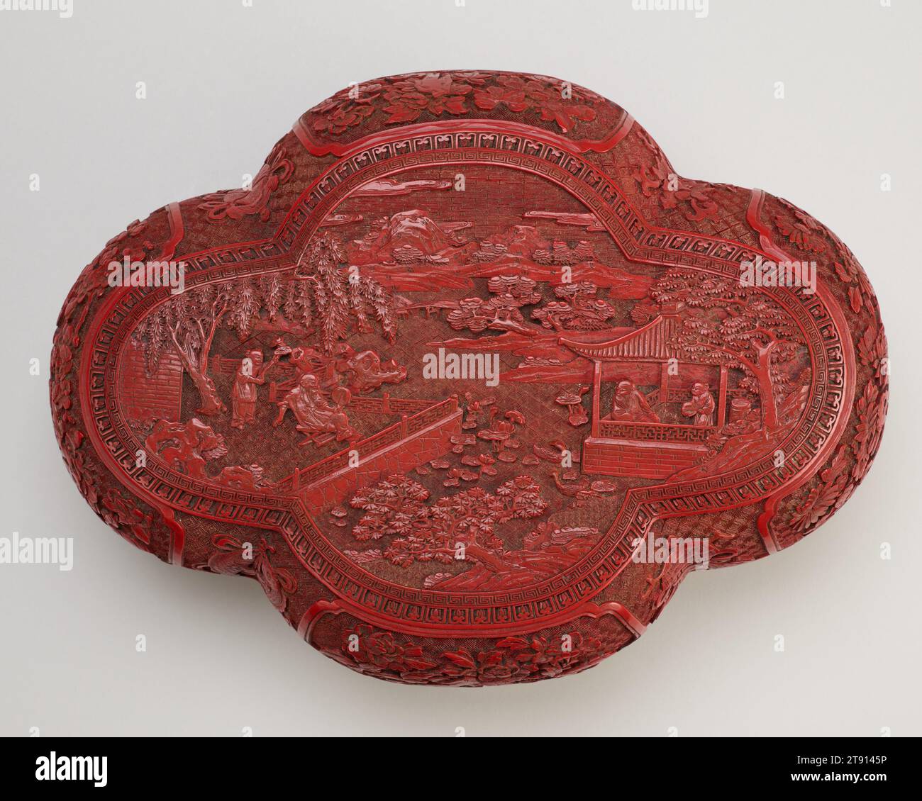 Quadrifoil Box, eins von einem Paar, 1662-1722, 4 1/8 x 8 1/4 x 11 Zoll (10,48 x 20,96 x 27,94 cm), geschnitzter roter Lack (Zinnober), China, 17. Bis 18. Jahrhundert, dieses Paar geschnitzter Lackkisten zeigt Szenen von Gelehrten in Landschaftsaufnahmen (obere Tafeln) und die acht buddhistischen glückverheißenden Embleme (Seiten): Das Rad, eine Muschelschale, ein Regenschirm, ein Baldachin, eine Lotusblume, gepaarte Fische, eine Vase und ein endloser Knoten. Bildgeschnitzter Lack wurde in der frühen Ming-Dynastie (1368–1644) vervollkommnet und blieb bis ins 20. Jahrhundert populär. Stockfoto