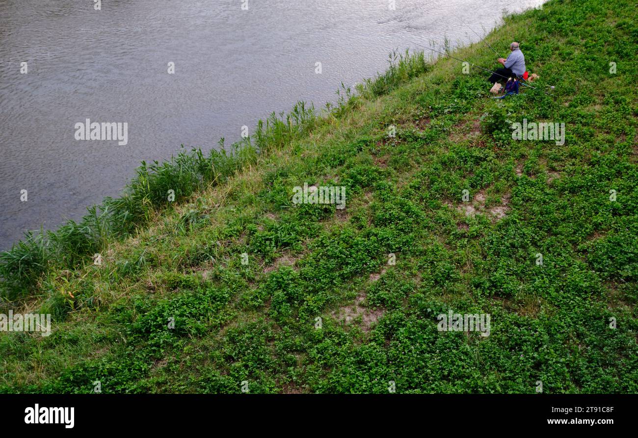 Ein Mann fischt am Ufer des Flusses Târnava Mare in Sighișoara, Rumänien, 30. Juli 2023. Foto von Tim Chong Stockfoto