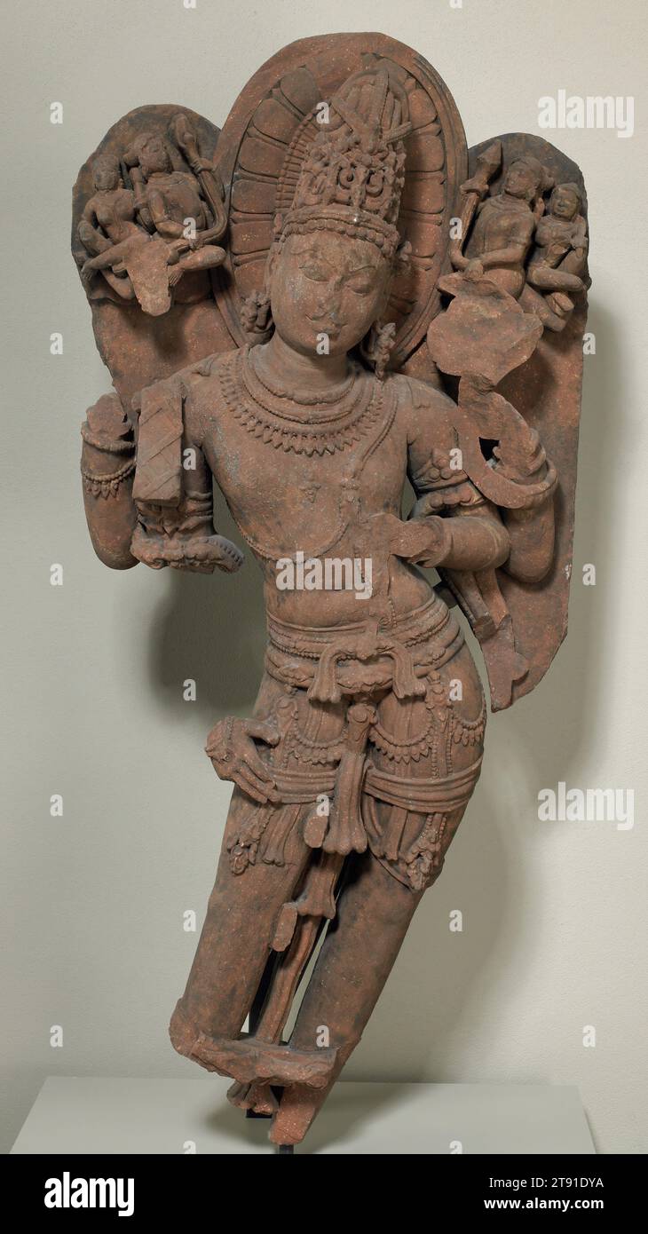Shiva, Ende des 10. Jahrhunderts, 48 1/4 x 22 1/4 x 9 1/2 Zoll (122,56 x 56,52 x 24,13 cm), Roter Sandstein, Indien, 10. Jahrhundert, elegant mit Juwelen an seinem Gürtel hängen, Ohrschmuck und einem aufwendig gewölbten Haarschmuck (Jatamukata), Shiva, der hinduistische Gott der Zerstörung und Regeneration, wird flankiert von verehrenden himmlischen Paaren gezeigt. Shivas dynamische Tribhanga-Pose ist untrennbar mit den vorgeschriebenen Bewegungen von Körper, Gliedmaßen und Handgesten des klassischen indischen Tanzes verbunden. Stockfoto