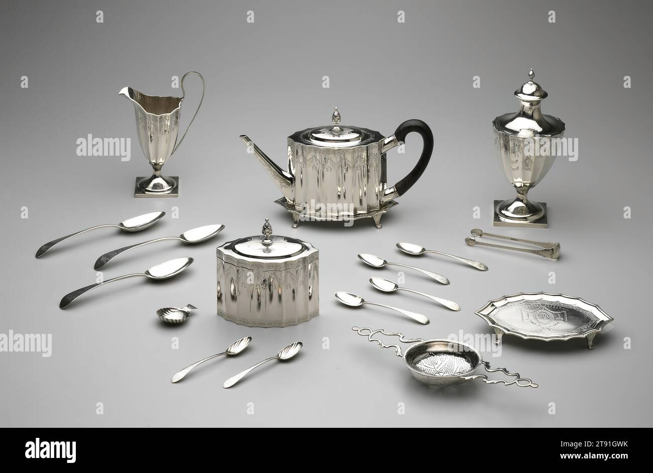 Tee Caddy Stand, von einem Tee-Service, 1792, Paul Revere, Jr., amerikanisch, 1734–1818, 5 3/4 x 5 1/2 Zoll (14,61 x 13,97 cm) (Teekaddy und Ständer), Silver and Wood, United States, Federal, dieses Set wurde für einen Bostoner Kaufmann und seine Frau John und Mehitable Templeman hergestellt. Es enthält einen von nur zwei Teewagen von Revere. In den verschlossenen Kisten war loser Tee, ein teures und modisches Gebrauchsgut. Der schalenförmige Löffel wurde zum Messen von Tee und das Sieb zum Absieben von Punsch verwendet, ein Getränk, das oft zusammen mit Tee serviert wird. Stockfoto