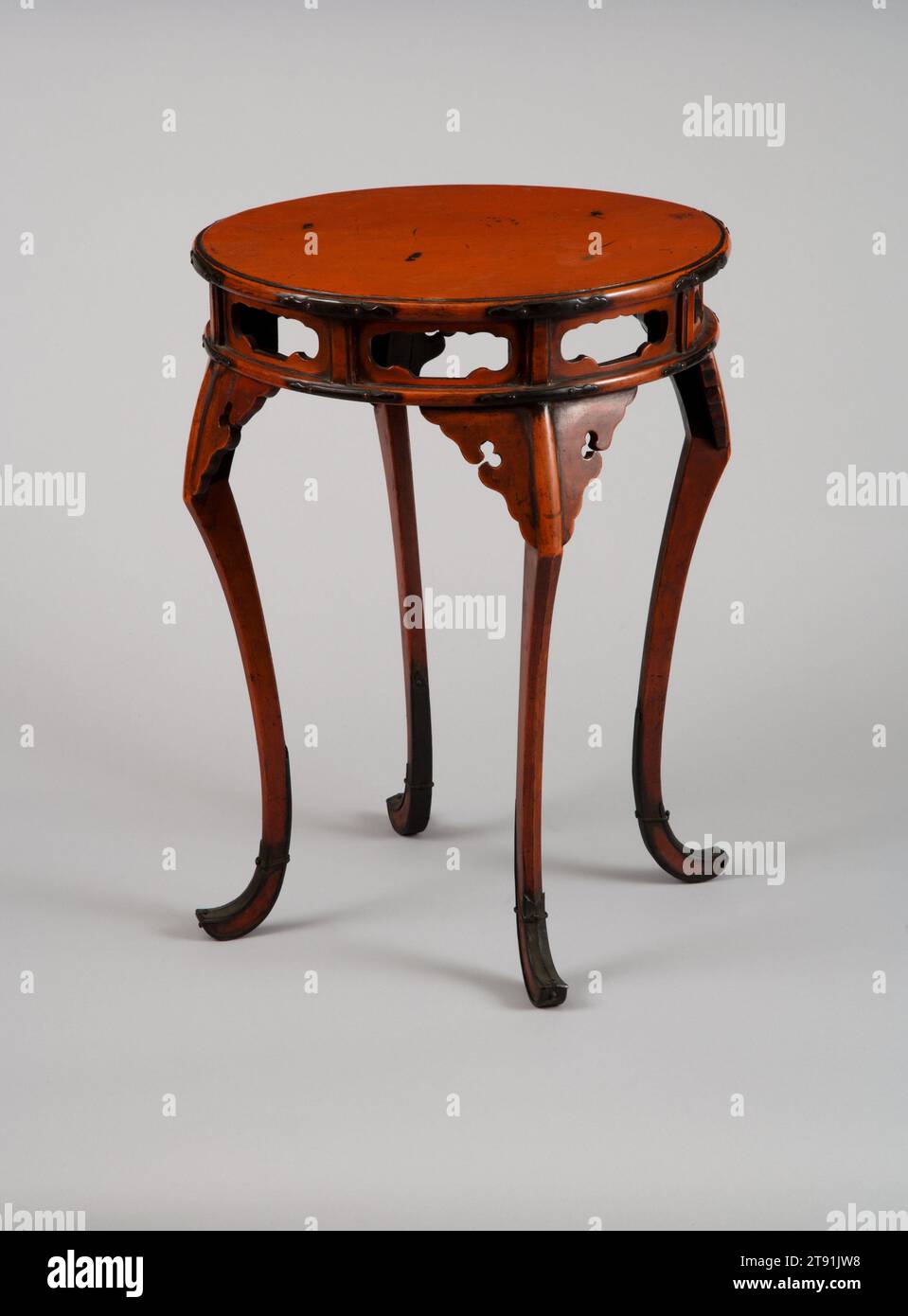 Lacktisch, 16. Jahrhundert, Unbekanntes Japanisch, 15 5/16 x 11 1/4 x 11 5/16 Zoll (38,89 x 28,58 x 28,73 cm), Negoro-Ware; roter Lack; Metallbeschläge, Japan, dieser elegante Tisch aus dem 16. Jahrhundert hätte ursprünglich einen Räucherbrenner oder ein anderes rituelles Objekt vor Ikonen in einem buddhistischen Tempel aufbewahrt. Diese Art von rotem Lack, bekannt als Negoro-Ware, spiegelt chinesischen Einfluss in seiner Gesamtform und geschnitzten Dekor wider. Negoro wird hergestellt, indem eine Basis aus schwarzem Lack mit rotem Lack bedeckt wird. Schließlich werden rote Bereiche von wiederholter Verwendung weggerieben, wodurch das darunter liegende Schwarz sichtbar wird. Stockfoto