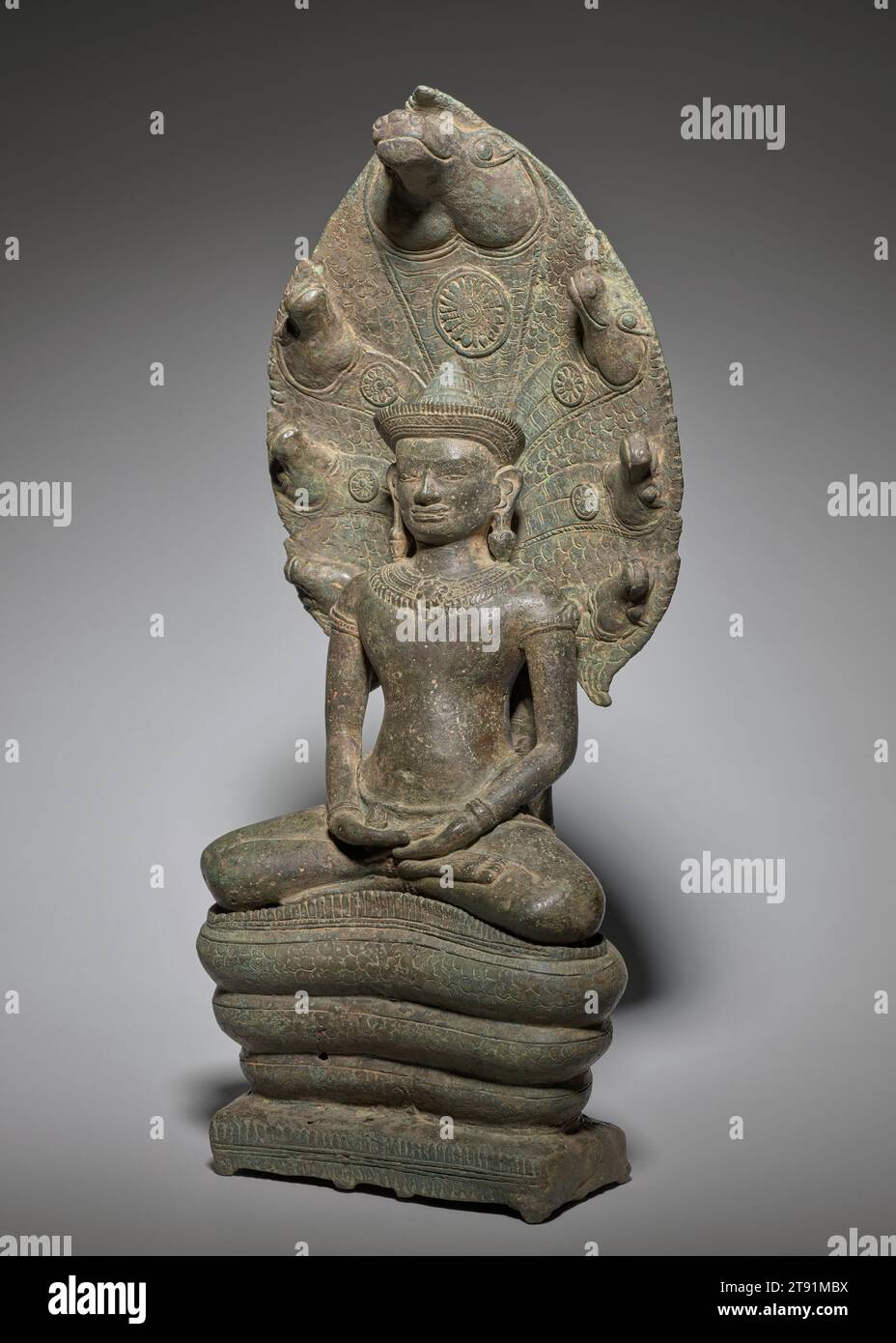 Naga-thronender Buddha, 12.-13. Jahrhundert, 16 3/8 x 6 5/8 x 3 13/16 Zoll (41,59 x 16,83 x 9,68 cm), Bronze, Kambodscha, 12.-13. Jahrhundert, Siddhartha Gautama, der Buddha wurde, erlangte Erleuchtung, nachdem er sieben Wochen lang unter einem alten Bodhi-Feigenbaum meditierte. Während dieser Zeit ertrug er eine Woche feuchten Regens, geschützt durch die ausbreitende Kapuze des Naga-Königs Mucalinda. Zusammen mit dem thailändischen „Walking Buddha“ gewann diese Darstellung des Buddha, der von Mucalinda geschützt wurde, in Südostasien eine besondere Bedeutung. Das Bild war unter dem Khmer-König Jayavarman VII. Populär Stockfoto
