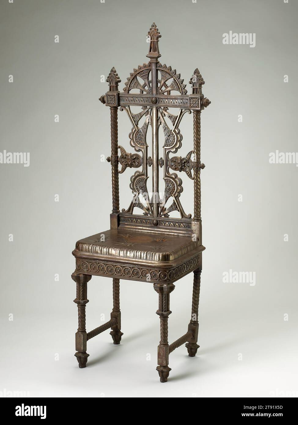 Side Chair, ca. 1870, Circle of Christopher Dresser; Hersteller: Masborough Stofengitter Company, Scottish, 1834-1904, 52 1/2 x 19 1/4 x 13 3/8 Zoll (133,35 x 48,9 x 33,91 cm), Eisen, Pigment, England, 19. Jahrhundert, Christopher Dresser, ein ausgebildeter Botaniker, der einer der ersten Industriedesigner in Großbritannien wurde, förderte innovatives Design, das vielen sozialen Klassen durch preiswerte, in Massenproduktion produzierte Objekte zur Verfügung stand. Die stilisierten Palmen und Disteln auf der Rückseite des Stuhls erscheinen auch auf dem gusseisernen Kleiderständer, der für die Coalbrookdale Company entworfen wurde. Der Trompe l'oeil Stockfoto