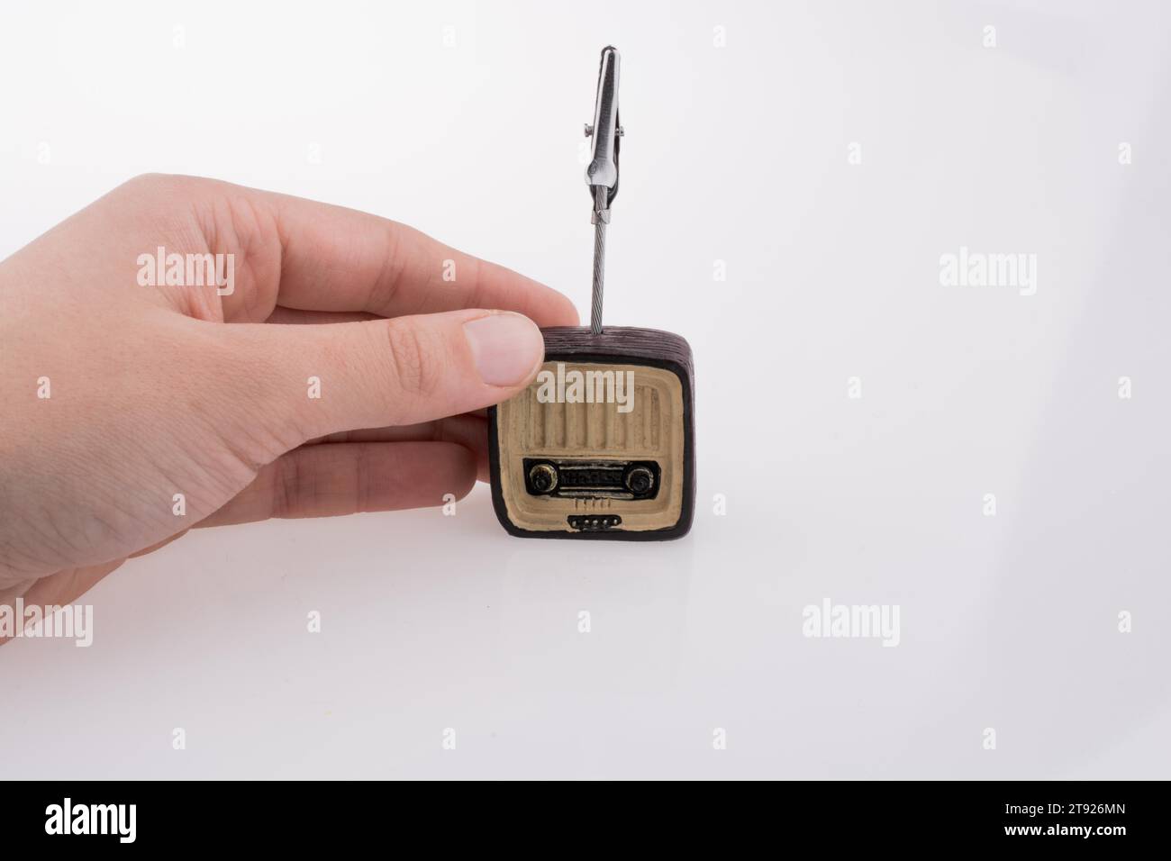 Hand mit einem Retro-TV-Modell auf einem weißen Hintergrund Stockfoto