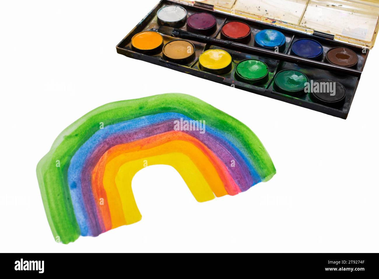 Das Kind zeichnet einen Regenbogen mit Farben Stockfoto