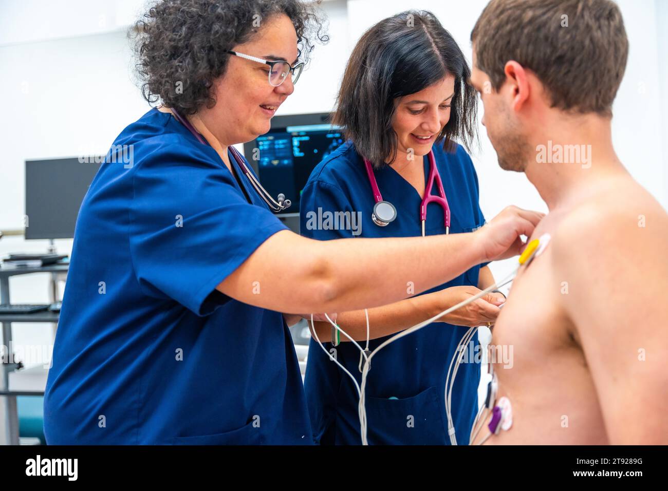 Kardiologe, der Elektroden für einen Belastungstest an einem Patienten platziert Stockfoto