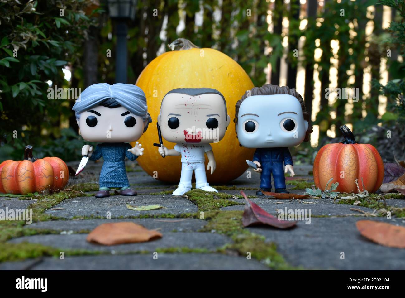 Funko Pop Actionfiguren der Horrorfiguren Norman Bates, Hannibal Lecter und Michael Myers. Halloween, gruselige Saison, Kürbisse, Moos, Blätter. Stockfoto