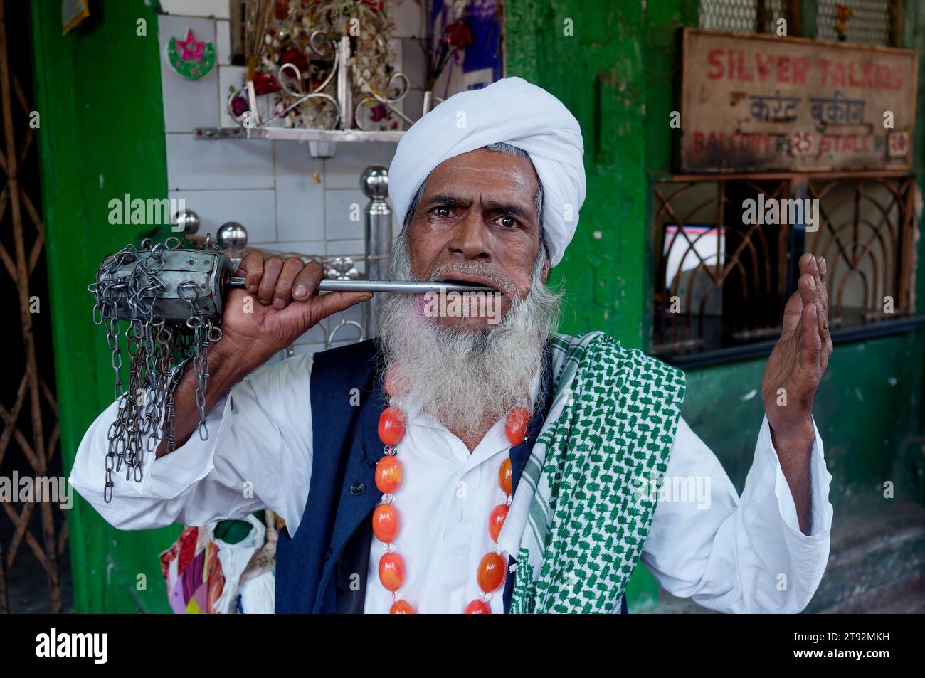 Ein Fakir, ein wandernder muslimischer Asket, der seltsame Meisterleistungen und magische Tricks vollführt und mit scharfer Speiche seine Wange durchbohrt; Mumbai, Indien Stockfoto