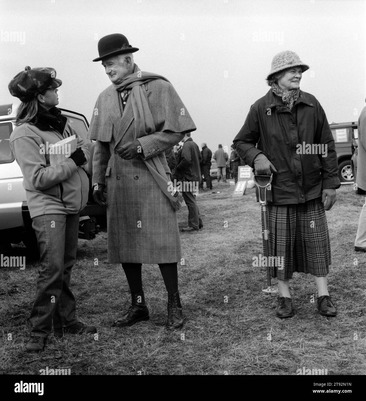 Hase Coursing 2002 UK. Der Waterloo Cup, eine dreitägige Veranstaltung, findet seit 1836 in der Nähe von Altcar statt. Modisch gekleideter Mann mit Bowler Hut und cape, mit Vieren, die nicht so gut waren, dass die Frau ihren Schießstock trug. Lancashire, England. 2002 HOMER SYKES Stockfoto