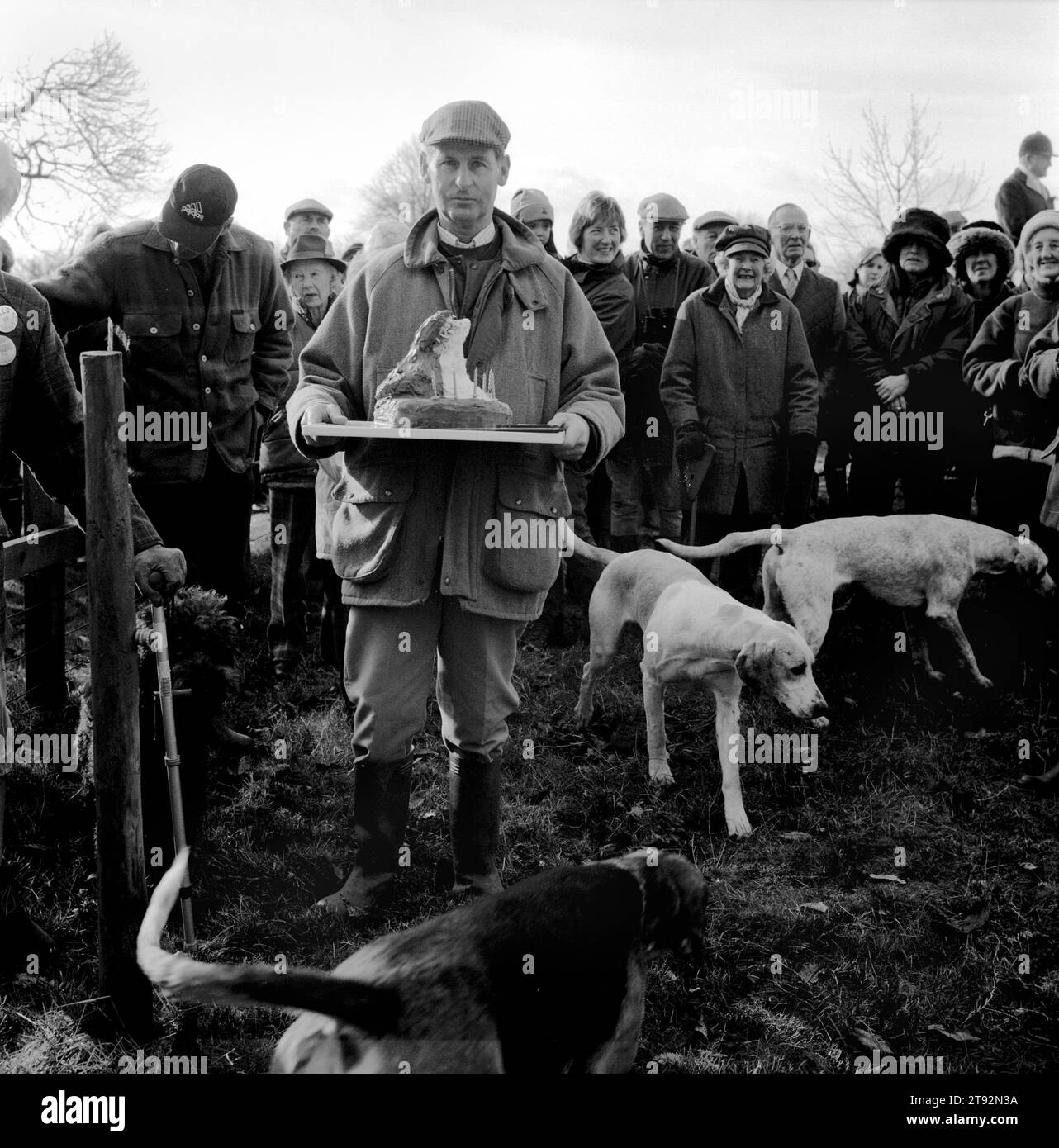 Der Herzog von Beaufort Hunt. Das Treffen vor den Tagen der Jagd beginnt im Haus von Mrs. Elizabeth Pope, um ihren 90. Geburtstag zu feiern. Es wird ein Schokoladenkuchen in Form einer montierten Fuchsmaske präsentiert, bevor er unter den Wappenschwärmern verteilt wird. In Der Nähe Von Avening, Gloucestershire. HOMER SYKES AUS DEN 2002 2000ER JAHREN Stockfoto