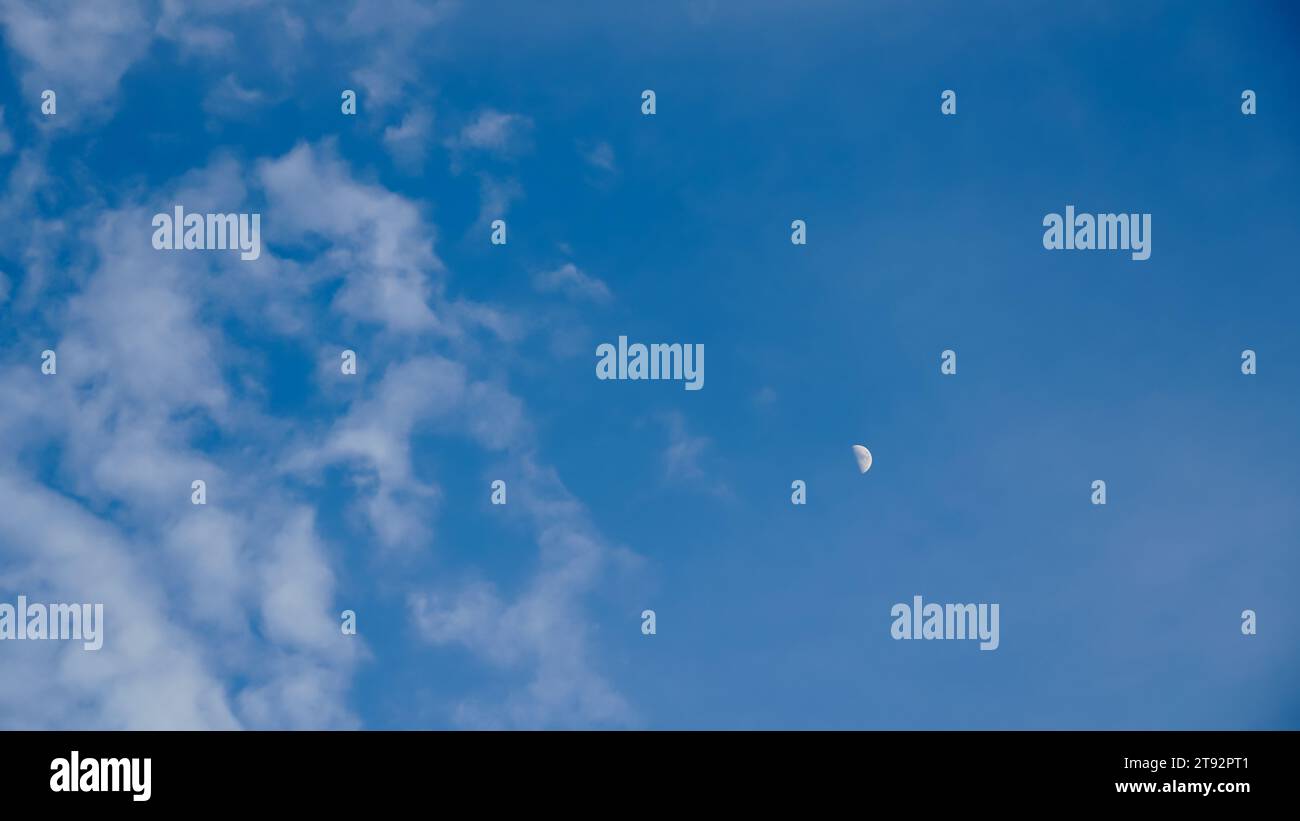 Halbmond am Himmel am Tag mit schlauen Wolken Umgebung Atmosphäre Hintergrund Hintergrund. Weiße Wolken und blauer Himmel. Wolken mit Hintergrund. Stockfoto