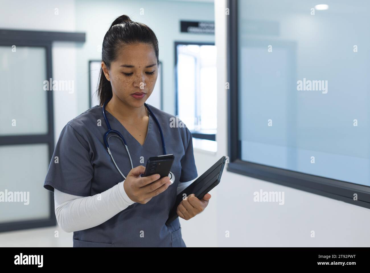 Birassische Ärztin mit Handschuhen im Krankenhauskorridor Stockfoto