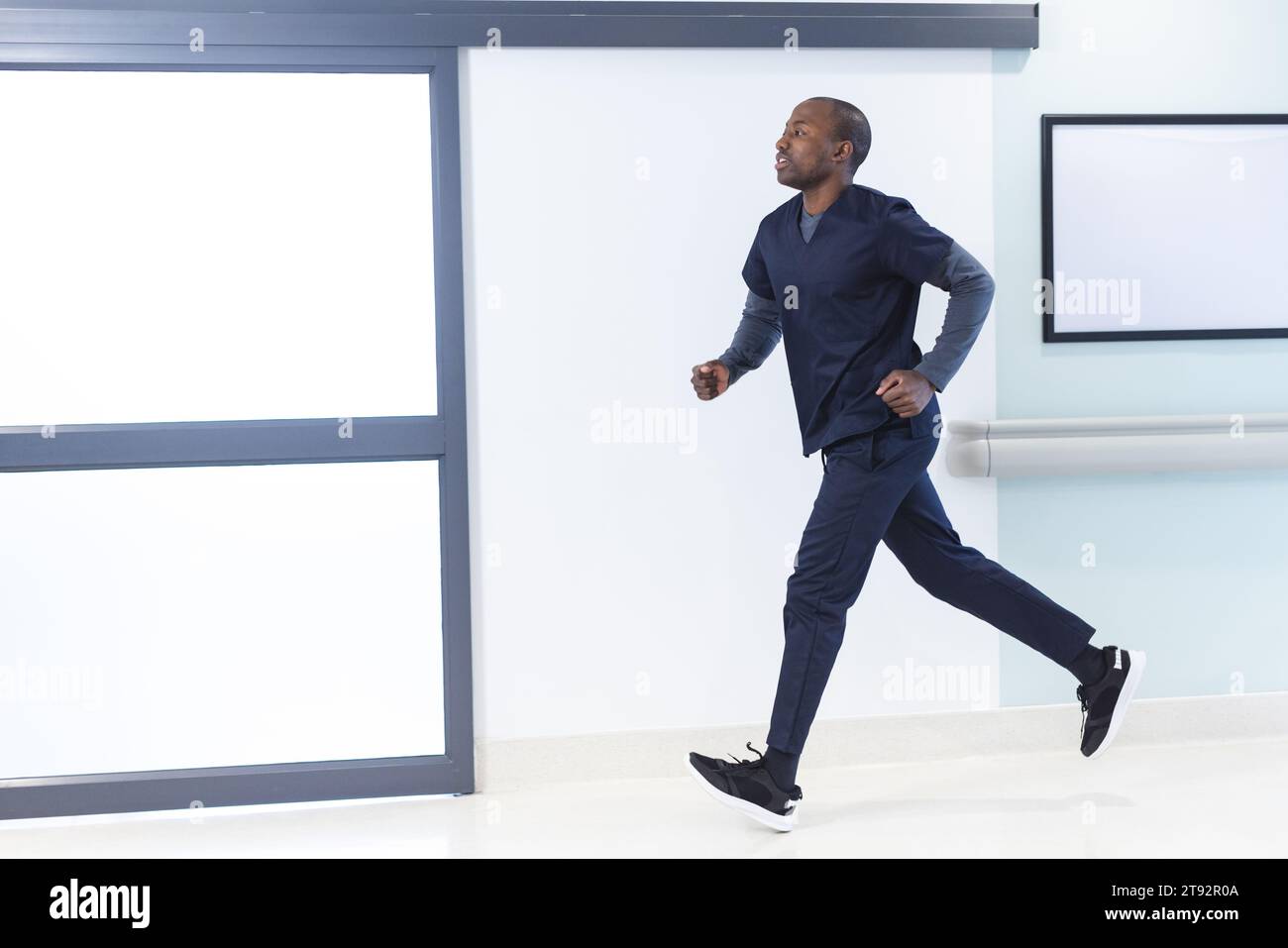 afroamerikaner, männlicher Arzt, der im Krankenhaus durch den Korridor läuft, Kopierraum. Medizin, Gesundheitswesen, Arbeit und Krankenhaus, unverändert. Stockfoto