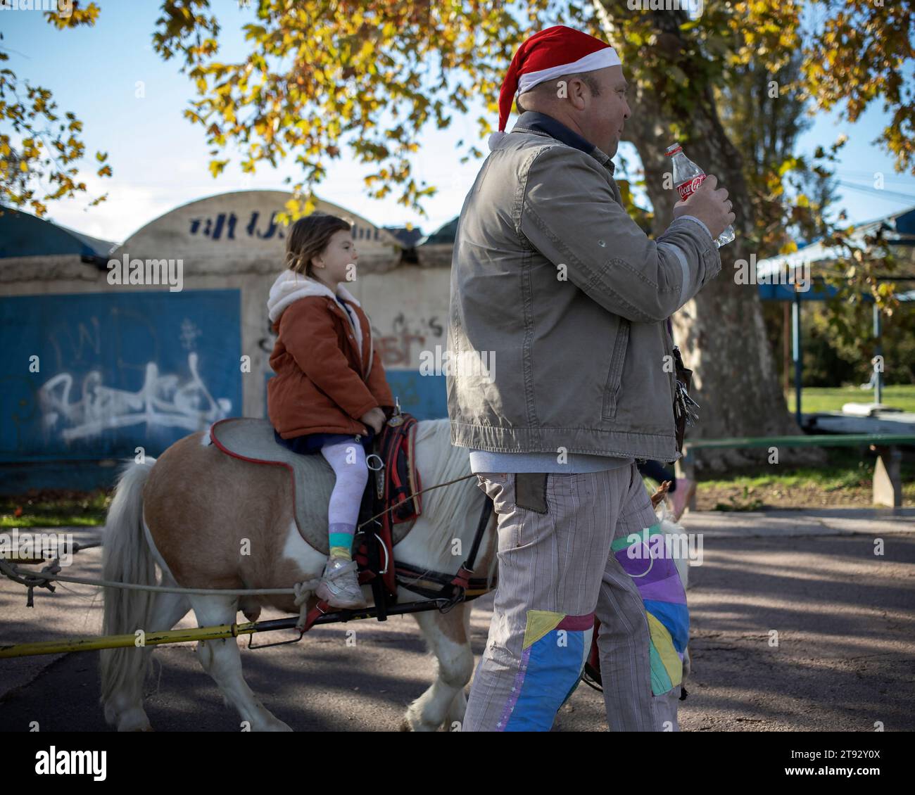 Belgrad, Serbien, 12. November 2023: Ein Mann, der ein Pony führt, wird von einem kleinen Mädchen geritten Stockfoto