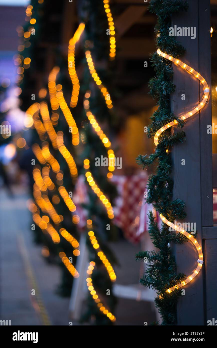 Tauchen Sie ein in das zauberhafte Leuchten festlicher Weihnachtslichter in diesem Bild im vertikalen Format. Das Foto zeigt eine Leuchtröhre, die sich entlang schlängelt Stockfoto