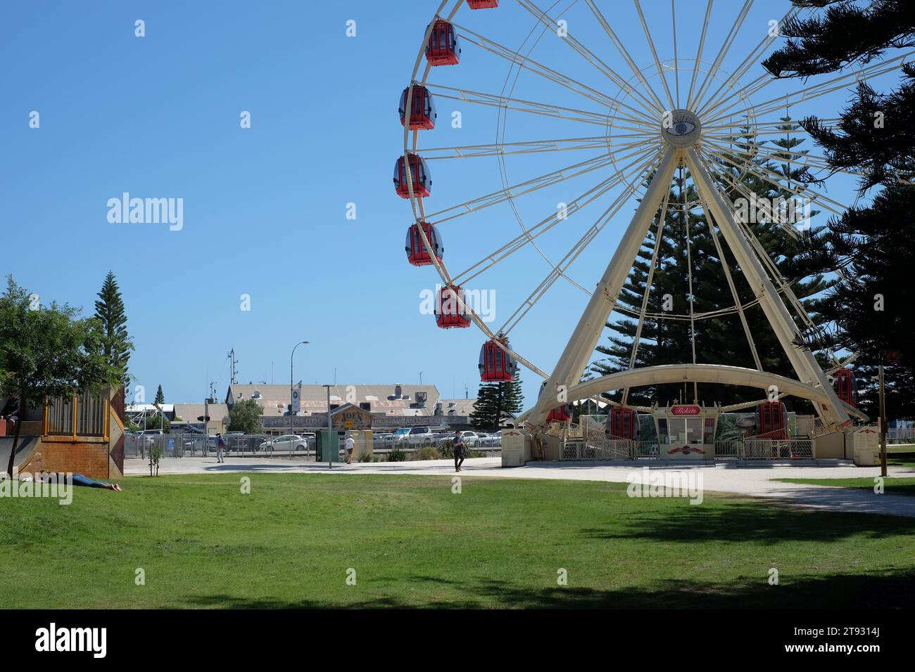 Touristenrad Fremantle, Ticketkiosk, grünes Gras und Fischerhafenrestaurants vor blauem Himmel an einem sonnigen Tag Stockfoto