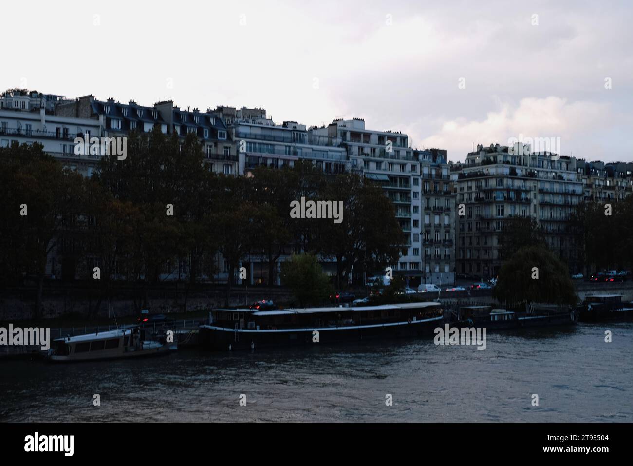 Skyline von Paris City mit Gebäuden, Booten auf dem Wasser und bewölktem Himmel im 15. Bezirk Stockfoto