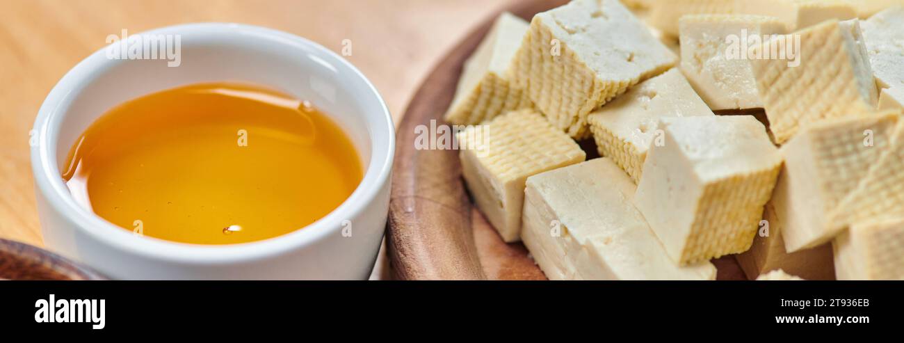 Tofu-Käse auf Holzteller und Keramikschale mit Olivenöl, vegetarisches Konzept, Banner Stockfoto