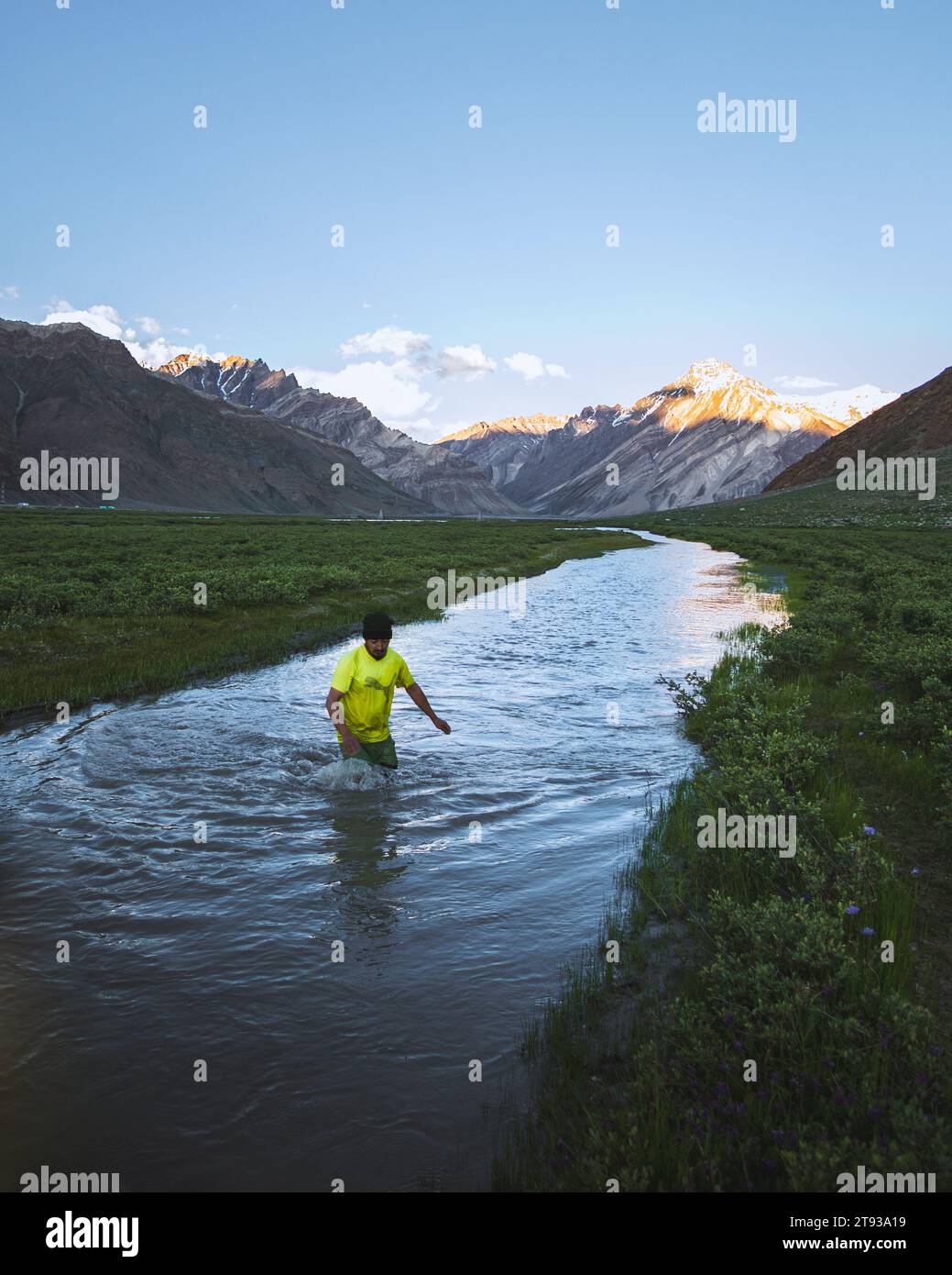 Ein paar Teenager, die versuchen, Fische in einem Bach mitten auf der Wiese zu fangen Stockfoto