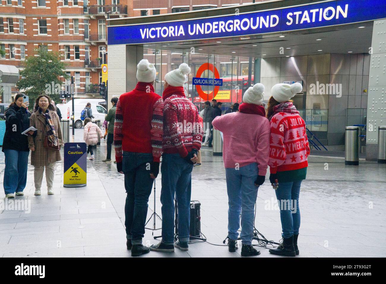 London, UK, 21. November 2021: Touristen beobachten vier Busfahrer in festlichen Springreitern, wie sie Weihnachtslieder am Cardinal Place in der Nähe des Victoria-Bahnhofs singen. Anna Watson/Alamy Live News Stockfoto