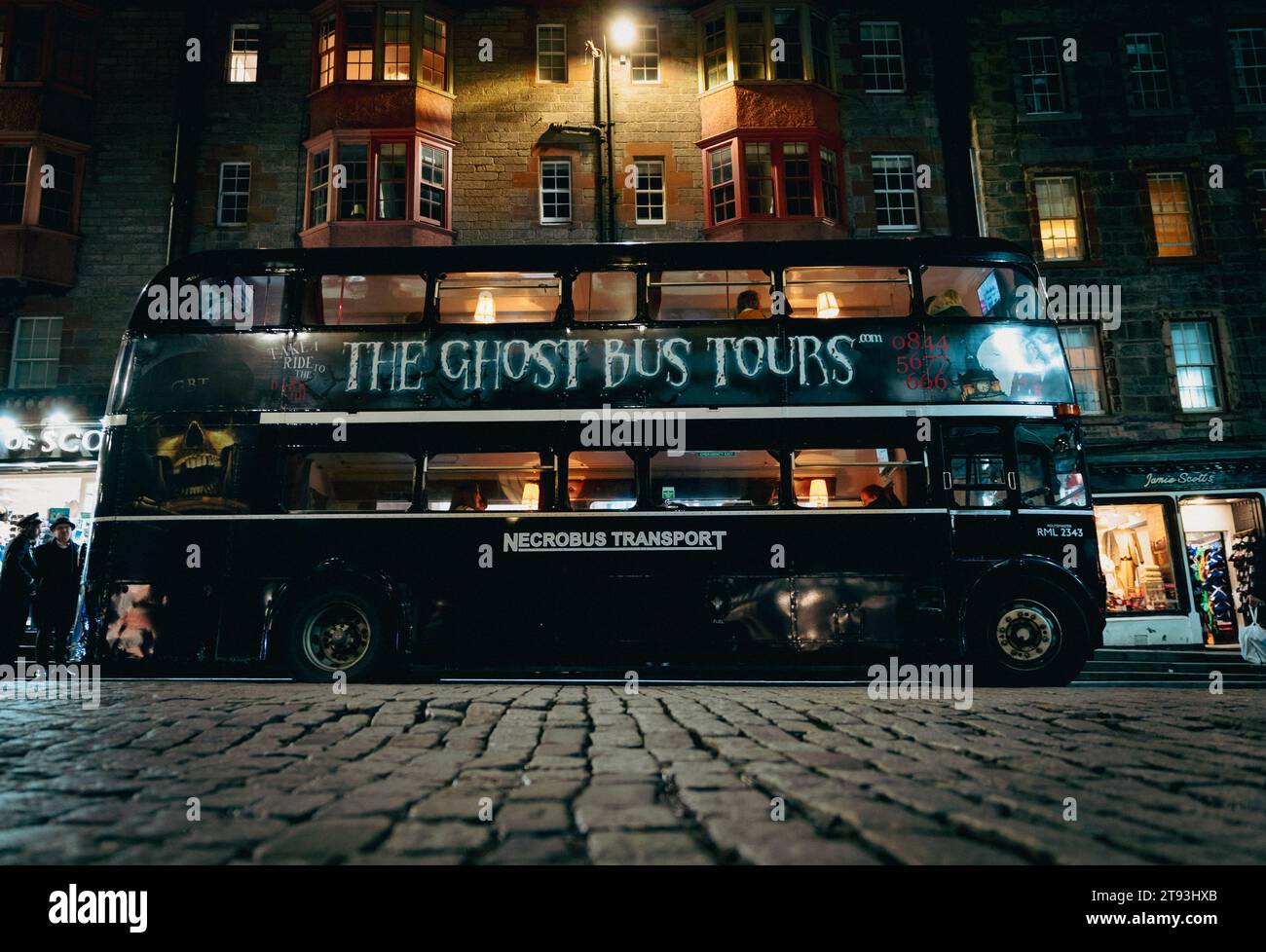Der touristische Ghost Bus Tours Doppeldeckerbus auf der Royal Mile bei Nacht Edinburgh, Schottland, Großbritannien Stockfoto