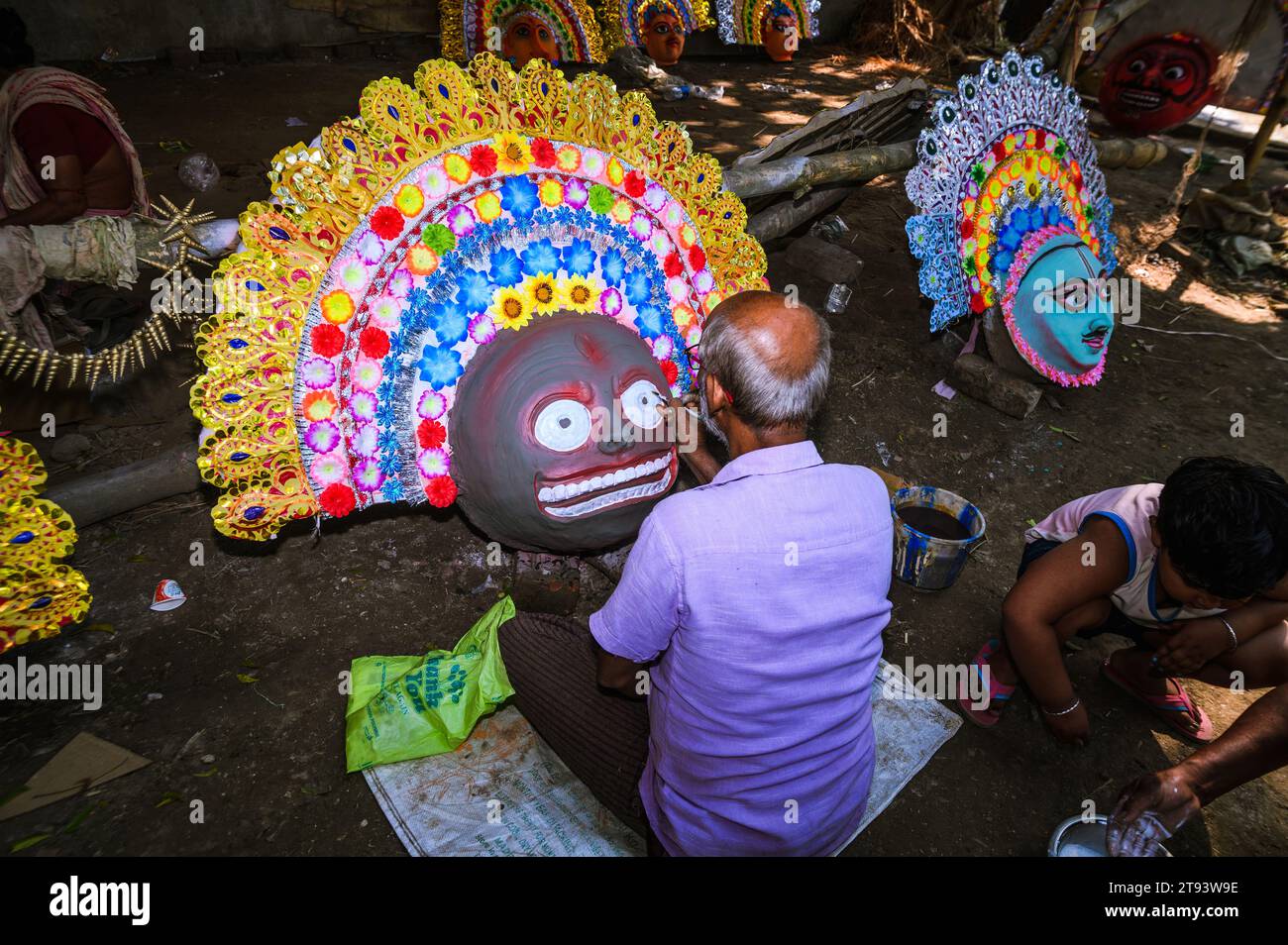 Ein Dorfidol-Künstler stellt große Farbmasken her, die Purulia Chhau Tanzmasken nachempfunden sind (Purulia Chhau Tanz ist auf der UNESCO-Liste der Tänze aufgeführt) von Göttinnen, Tieren und Rakshasas (humanoide Dämonen oder ungerechte Geister) wie hinduistische Mythologie-Charaktere aus Ton. Der Künstler malt dann die Götzenbilder mit Farbe, um sie in einem Jagaddhatri Puja Pandal zu installieren. Tehatta, Westbengalen, Indien. Stockfoto