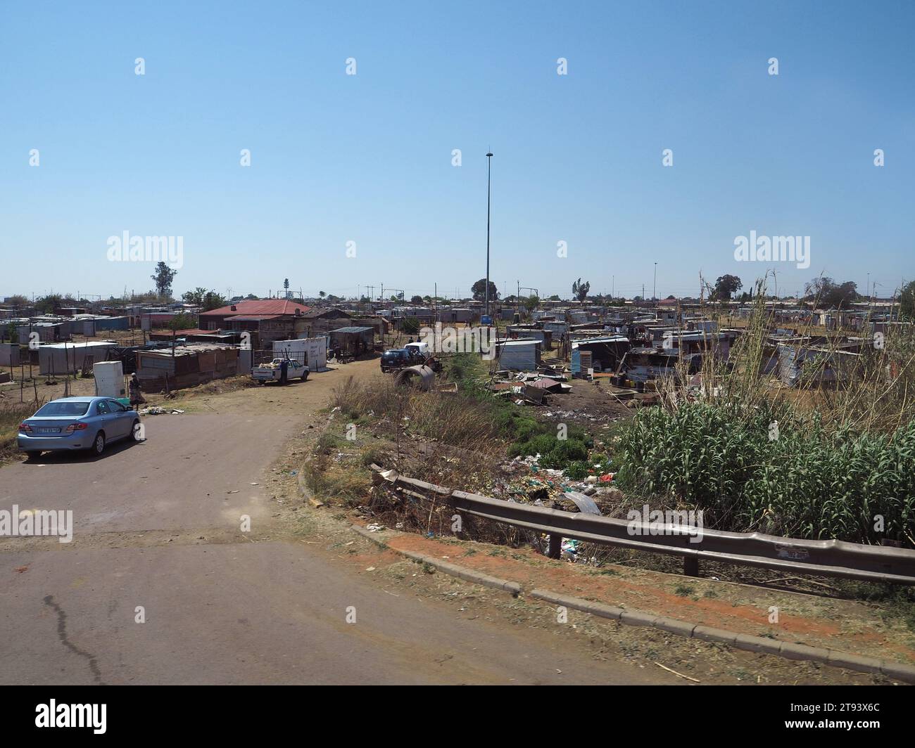 Straße, die in das Slum-Gebiet in Soweto Township, Gauteng, Südafrika führt. Stockfoto
