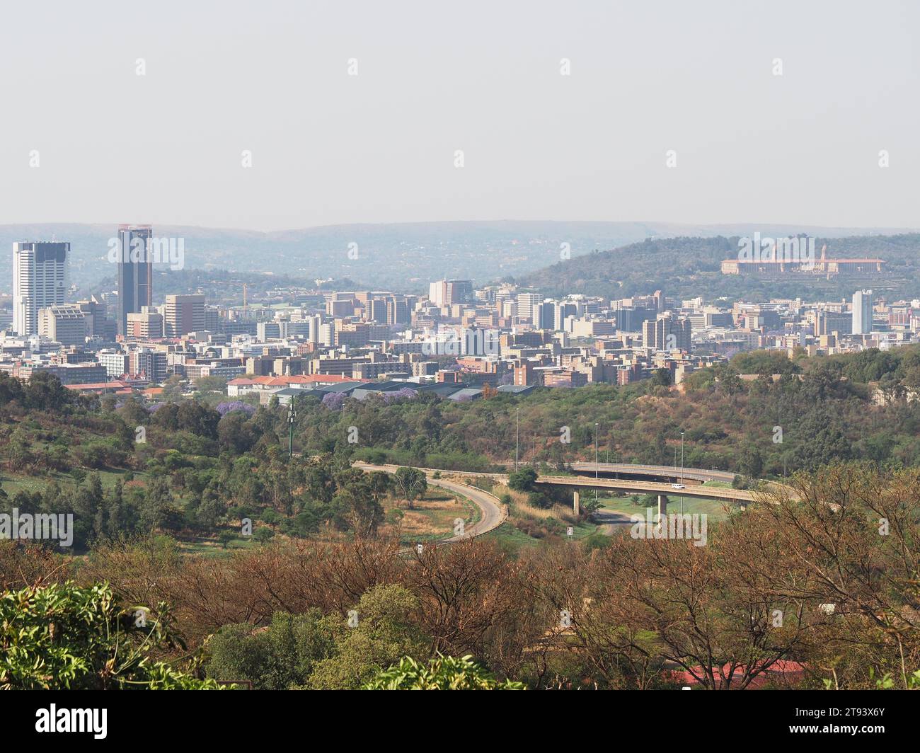 Die Stadt Pretoria, die Verwaltungshauptstadt, aus der Ferne gesehen, mit Autobahnen und Natur im Vordergrund. Pretoria, Gauteng, Südafrika. Stockfoto