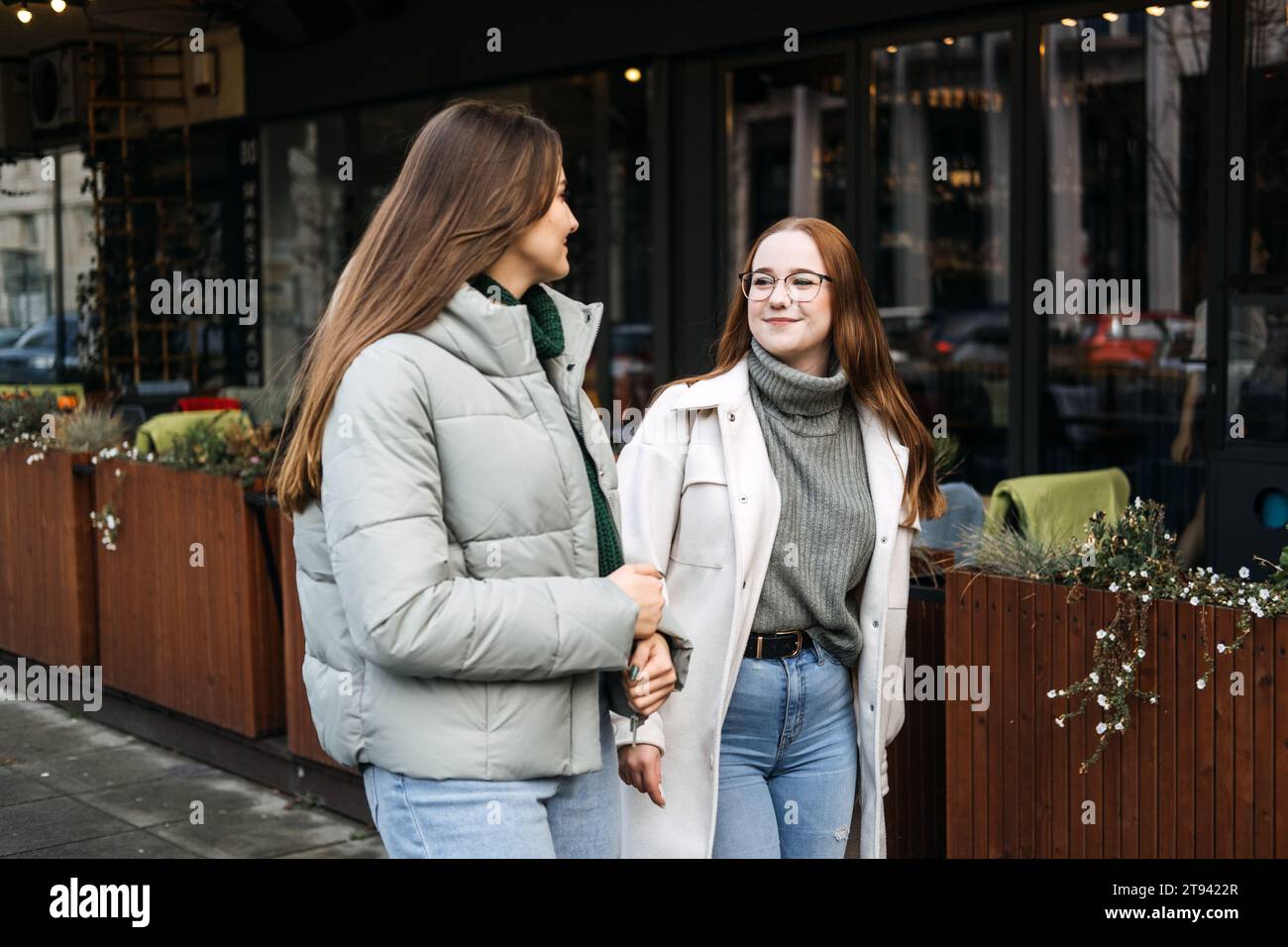 Freunde digitale Detox. Zwei Freunde genießen ein persönliches Gespräch auf dem Bürgersteig in der Stadt, digitale Detox durch persönliche Interaktion ohne Stockfoto
