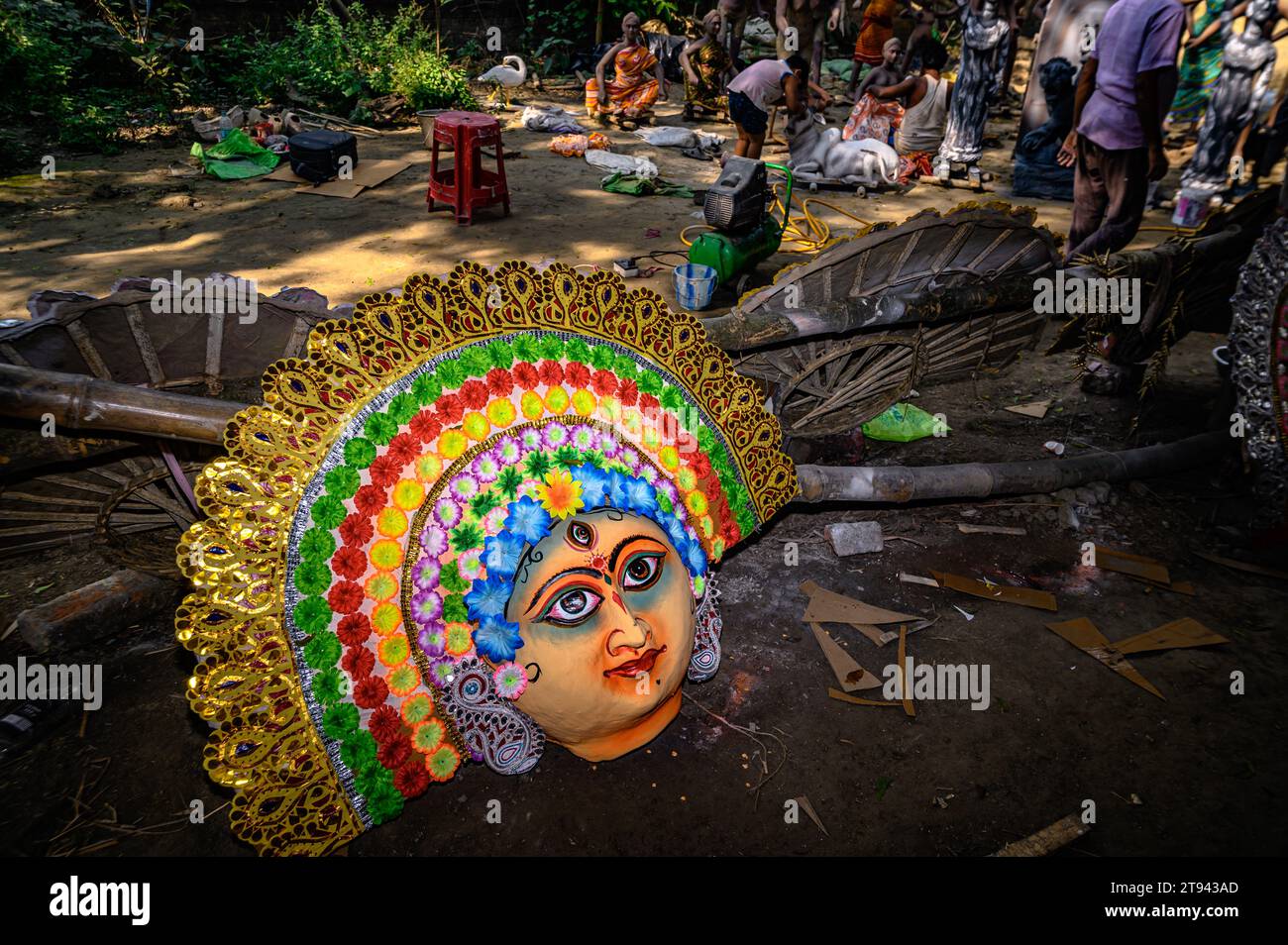 Ein Dorfidol-Künstler stellt große Farbmasken her, die Purulia Chhau Tanzmasken nachempfunden sind (Purulia Chhau Tanz ist auf der UNESCO-Liste der Tänze aufgeführt) von Göttinnen, Tieren und Rakshasas (humanoide Dämonen oder ungerechte Geister) wie hinduistische Mythologie-Charaktere aus Ton. Der Künstler malt dann die Götzenbilder mit Farbe, um sie in einem Jagaddhatri Puja Pandal zu installieren. Tehatta, Westbengalen, Indien. Stockfoto