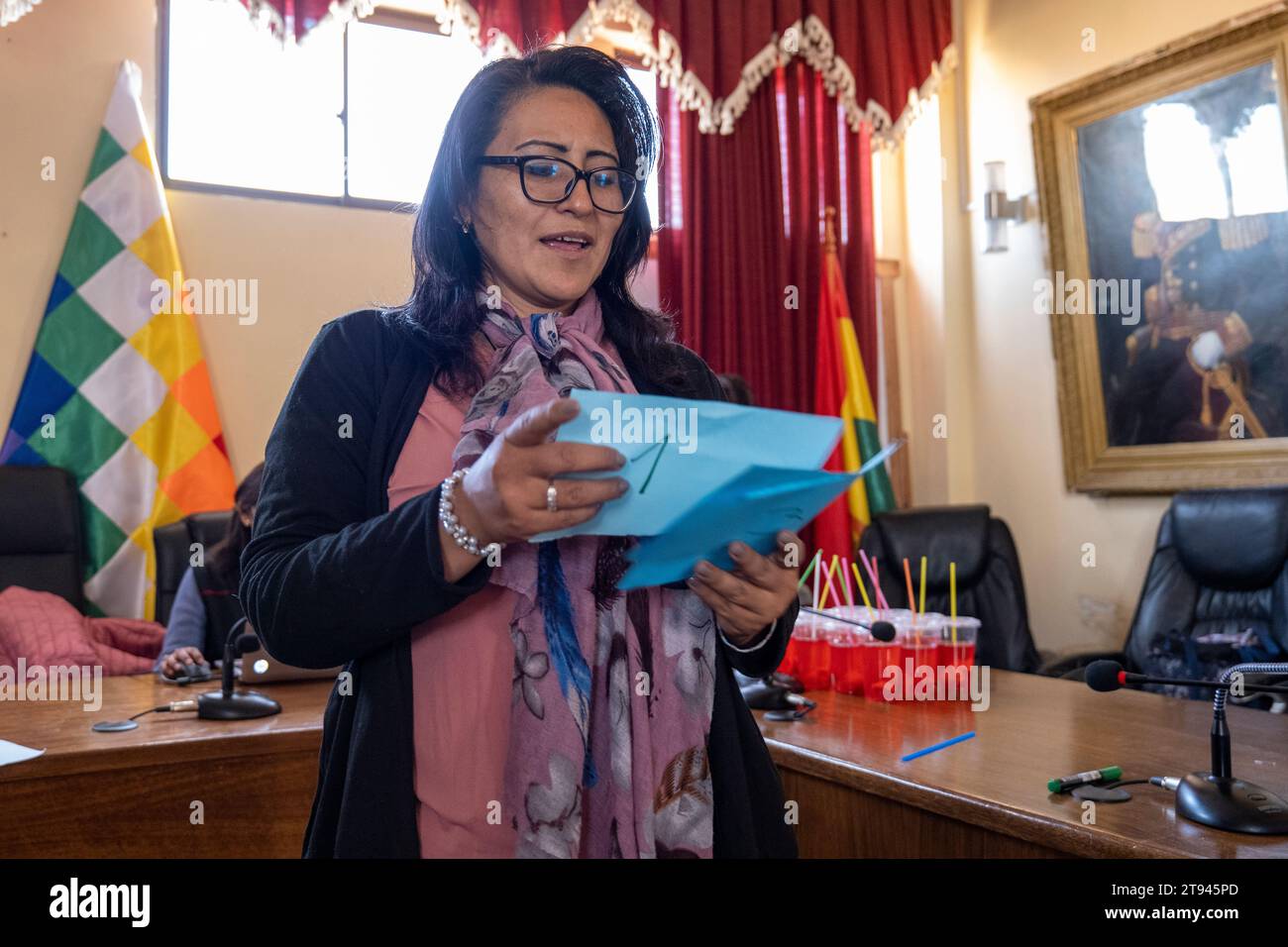 Viacha, La Paz, Bolivien – 16. August 2022: Bolivianische Frau spricht in einem Konferenzraum mit einer Wiphala-Flagge Stockfoto