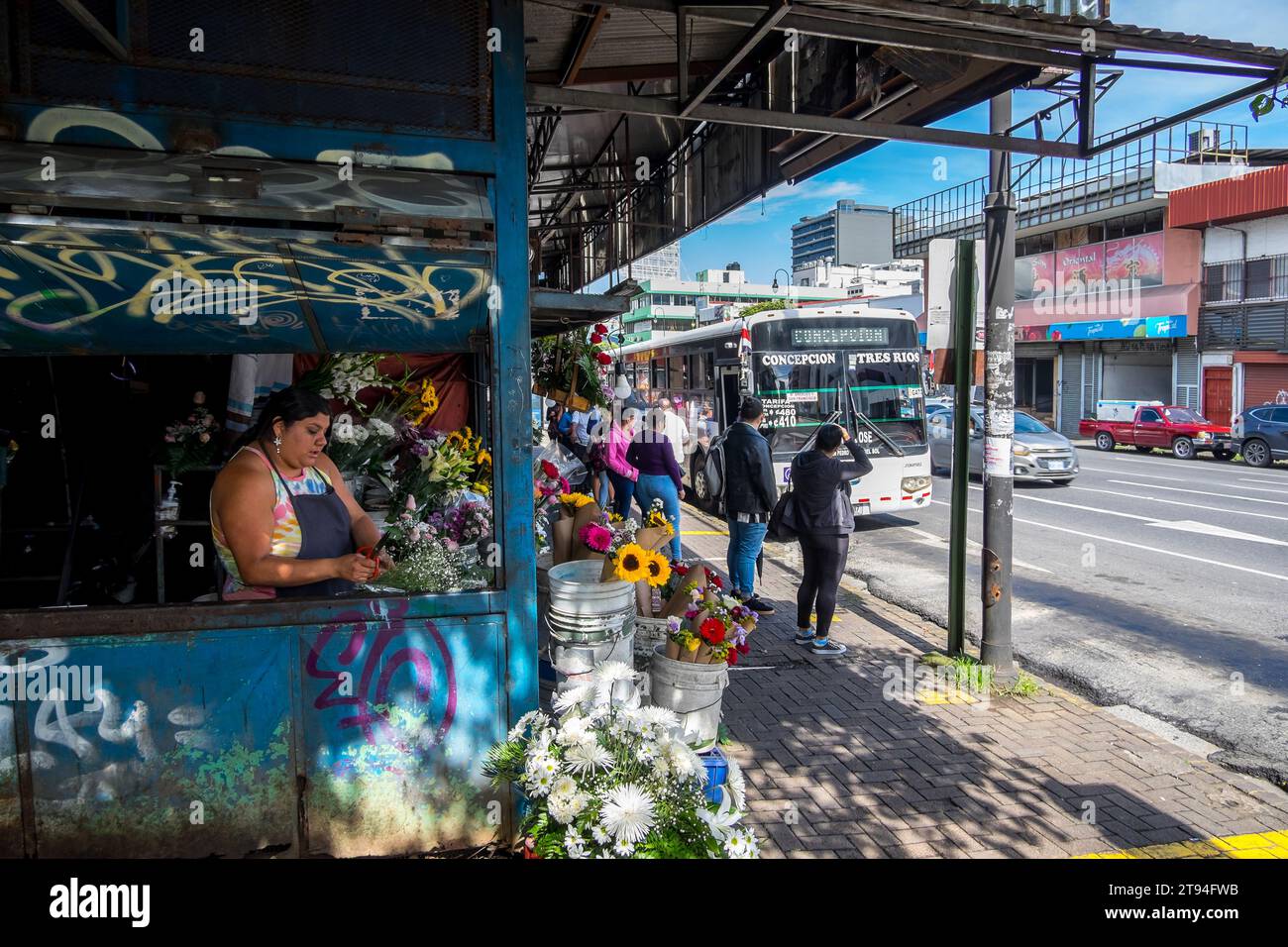 Blumenstand und Bushaltestelle auf einer zentralen Straße in der Stadt San Jose, Hauptstadt von Costa Rica Stockfoto