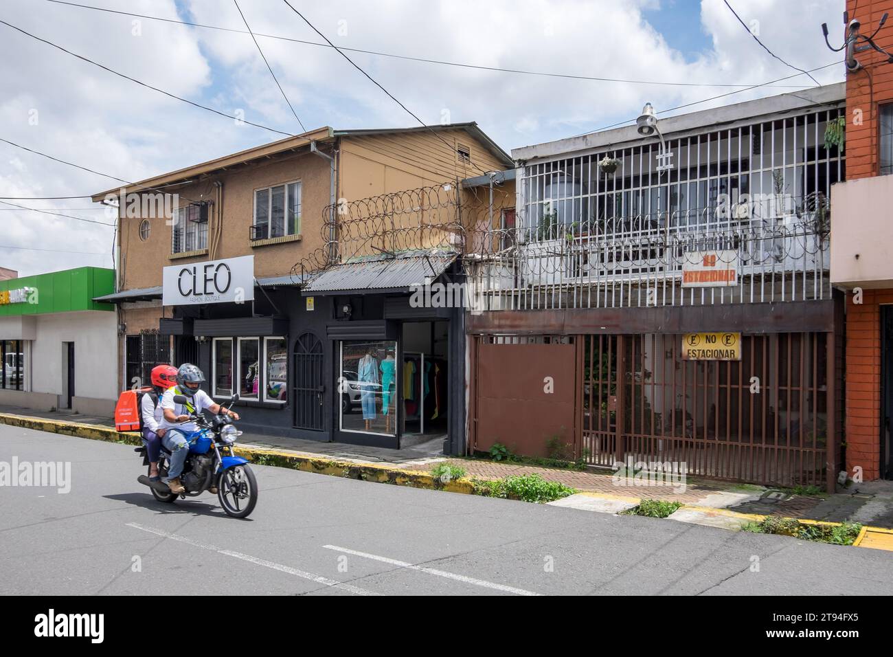 Szene mit Häusern und Motorrad in einem Wohnviertel der Stadt San Jose, Hauptstadt von Costa Rica Stockfoto