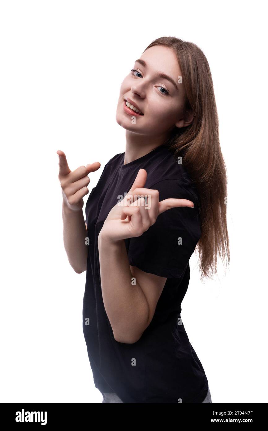 Ein hellhaariges Teenager-Mädchen in einem schwarzen T-Shirt zeigt ihr seidiges Haar Stockfoto