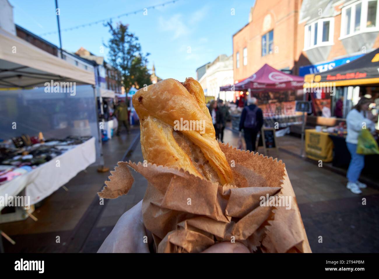 Spaziergang mit Wurstbrötchen an Marktständen im Winter an einem samstagtag in der Marktstadt ormskirk, lancashire, england, großbritannien Stockfoto