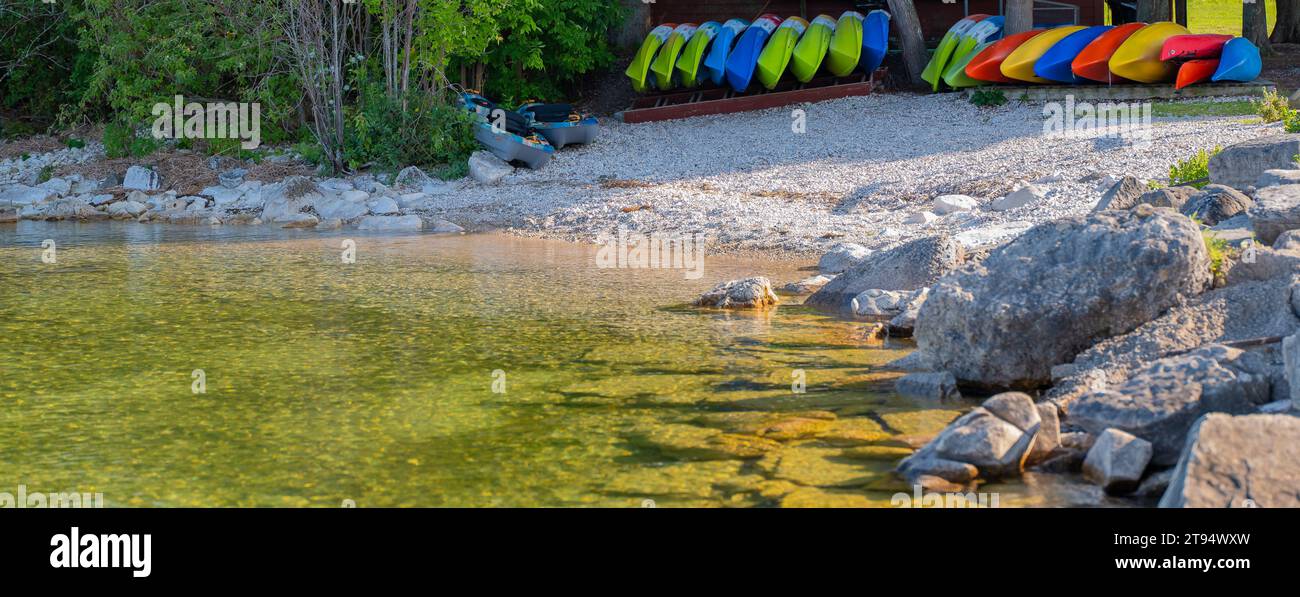 Seeszene an einem Strand mit farbenfrohen Kajaks in der Nähe des Wassers, die gemietet werden können. Stockfoto