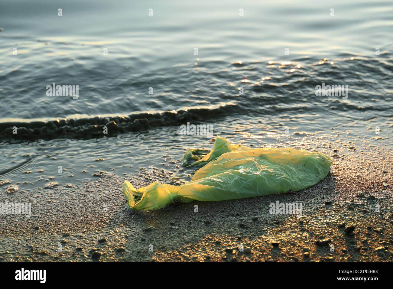 Benutzte Plastiktüte in der Nähe des Wassers am Strand. Umweltverschmutzung Stockfoto