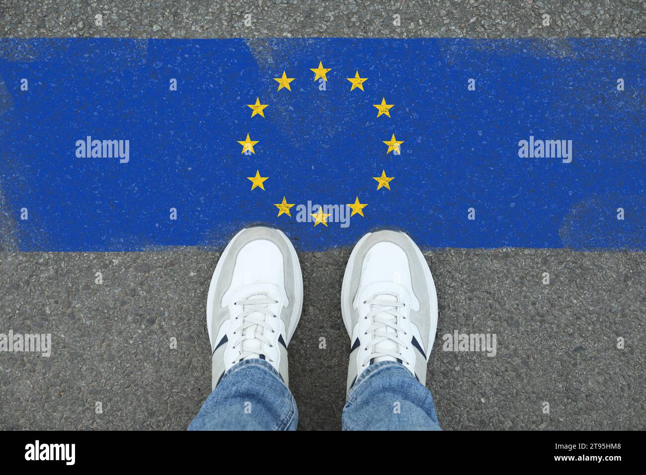 Einwanderung. Mann, der auf Asphalt steht, nahe der Flagge der Europäischen Union, Blick von oben Stockfoto