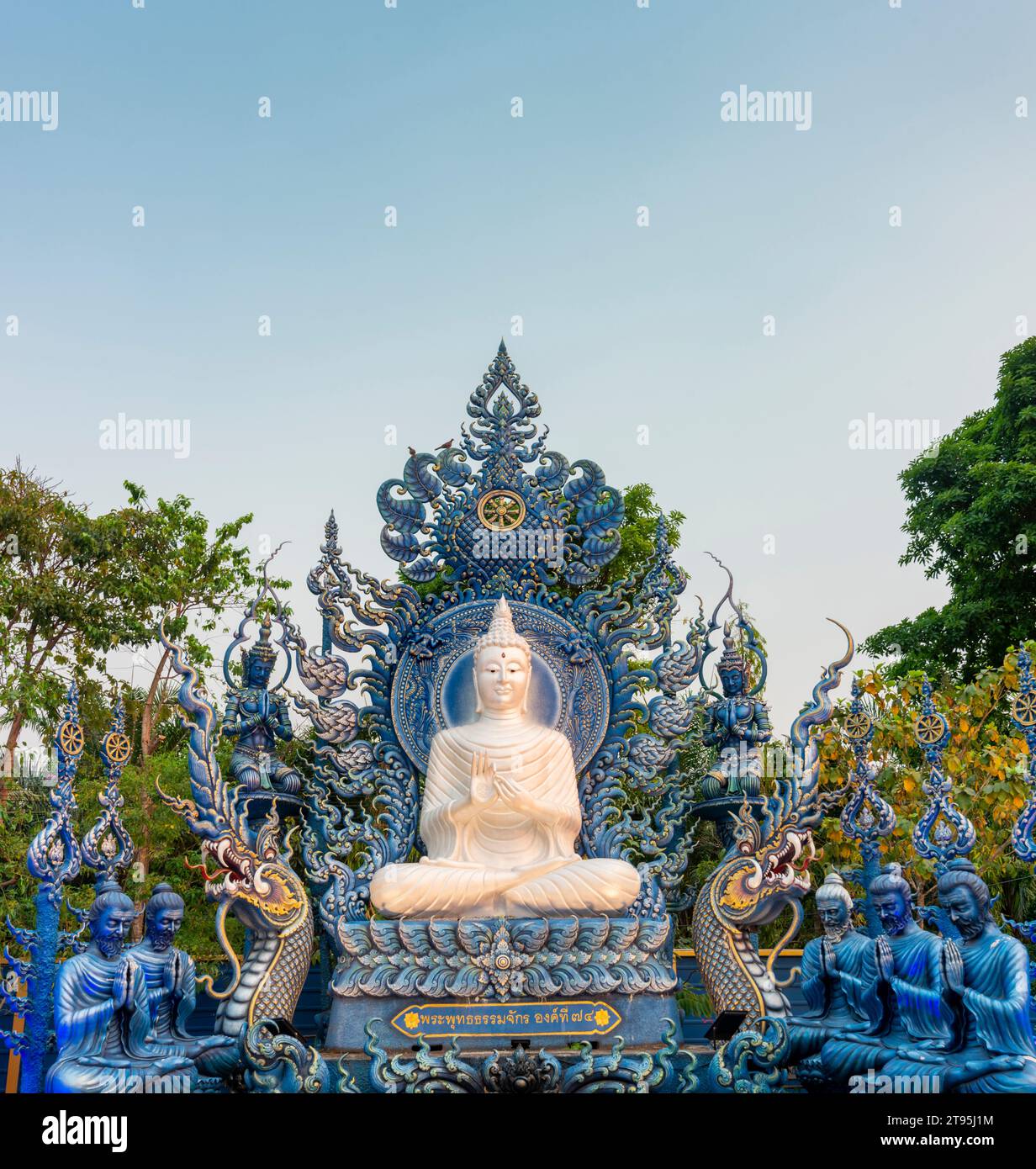 Wunderschön dekoriert mit blauen und goldenen Designs, exquisite weiße Buddha-Statue in der Nähe des Tempeleingangs, mit antiken historischen Figuren. Stockfoto