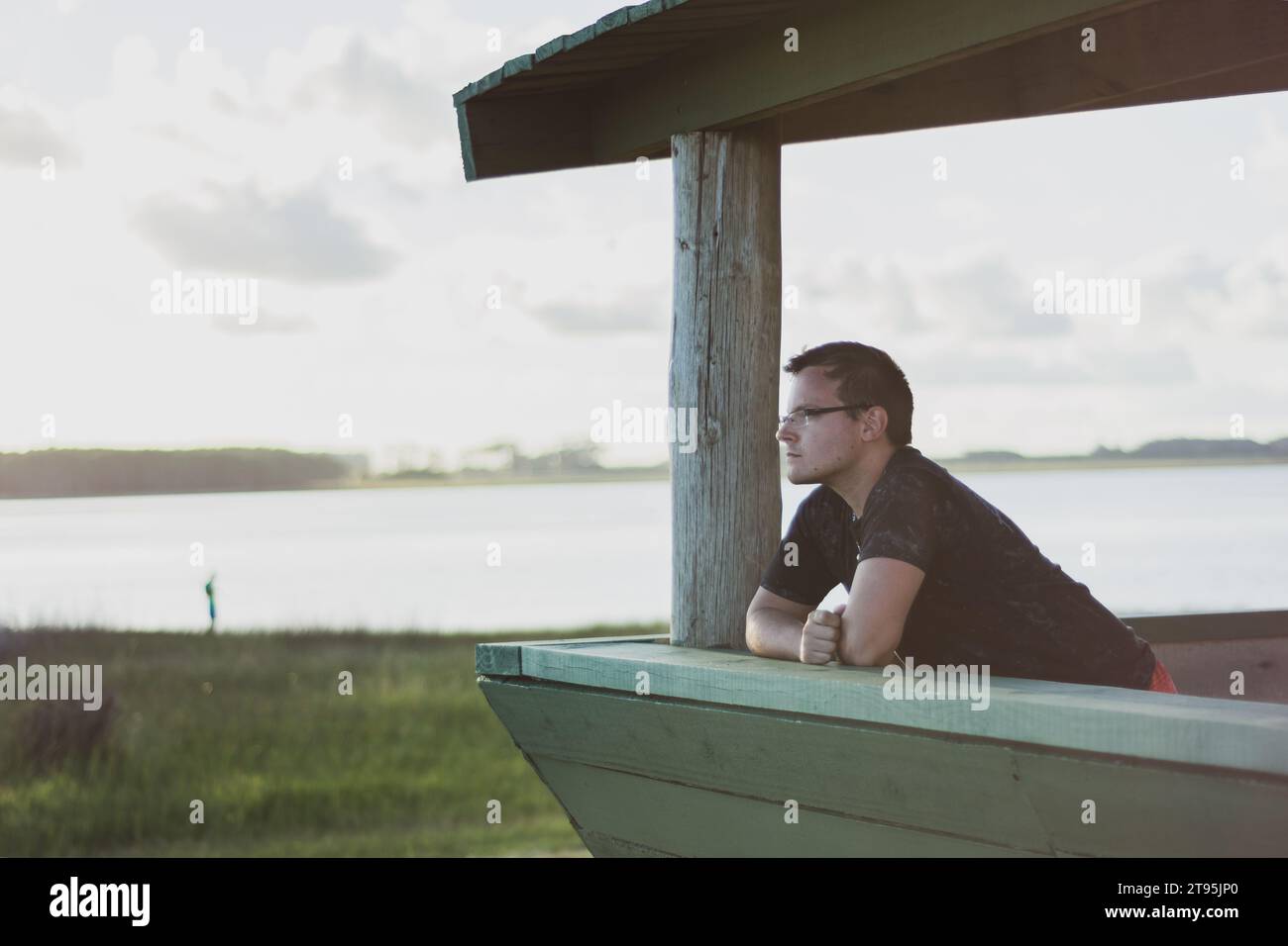 Person, die aus dem Fenster einer Hütte schaut Stockfoto