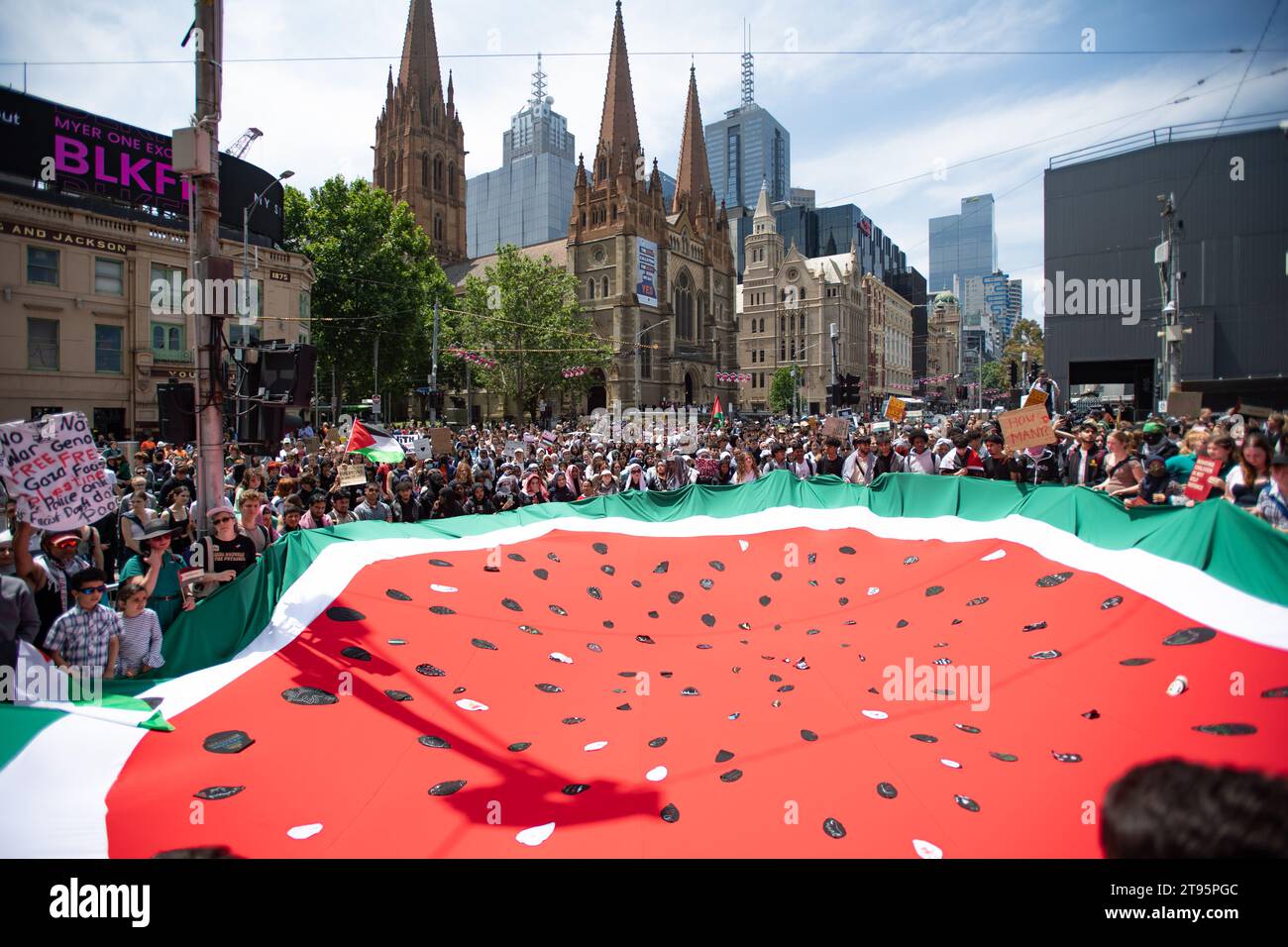 23. November 2023, Melbourne, Australien. Schulschüler aus Melbourne halten eine riesige Wassermelonenfahne, ein Symbol des palästinensischen Widerstands, während eines Streifens gegen den anhaltenden Krieg gegen Gaza, was Bewusstsein schafft und zu einem Waffenstillstand aufruft. Quelle: Jay Kogler/Alamy Live News Stockfoto