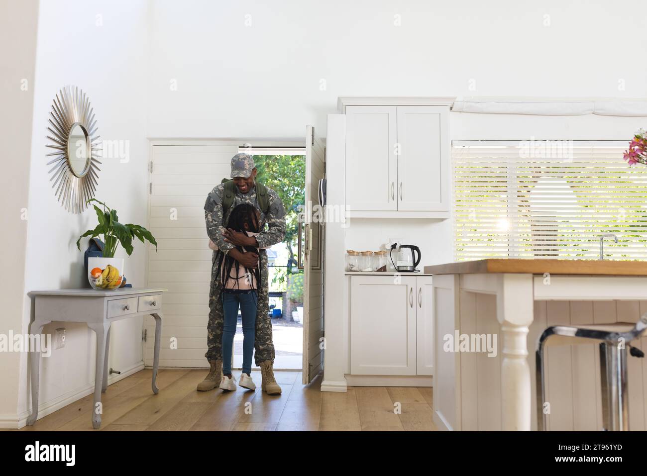 Glücklicher afroamerikanischer Soldat, der die Tochter zu Hause umschließt, Kopierraum Stockfoto