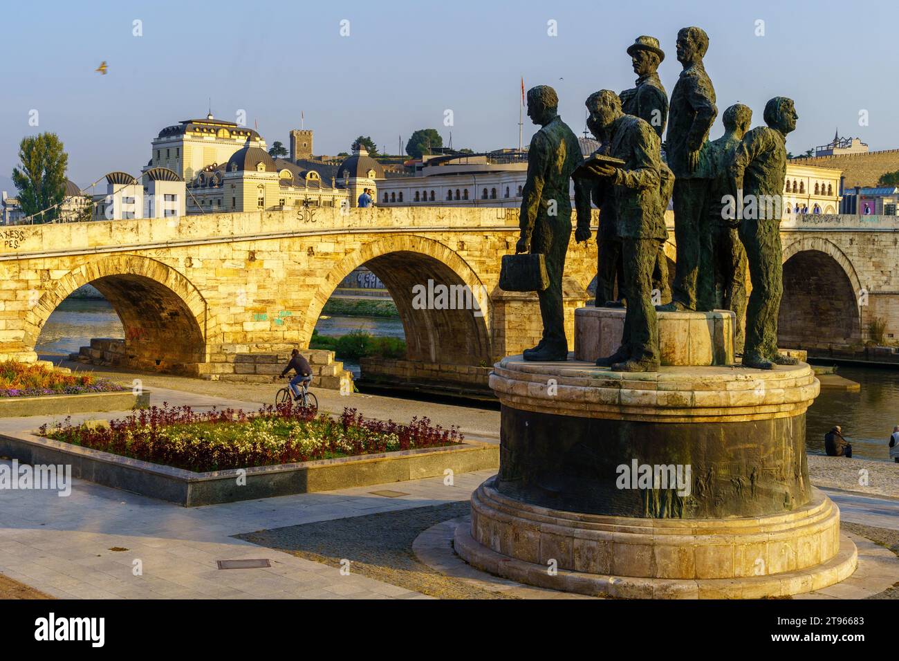 Skopje, Nordmakedonien - 5. Oktober 2023: Blick auf das Denkmal der Boote von Thessaloniki und die Steinerne Brücke, mit Einheimischen und Besuchern, in Skopje, N Stockfoto
