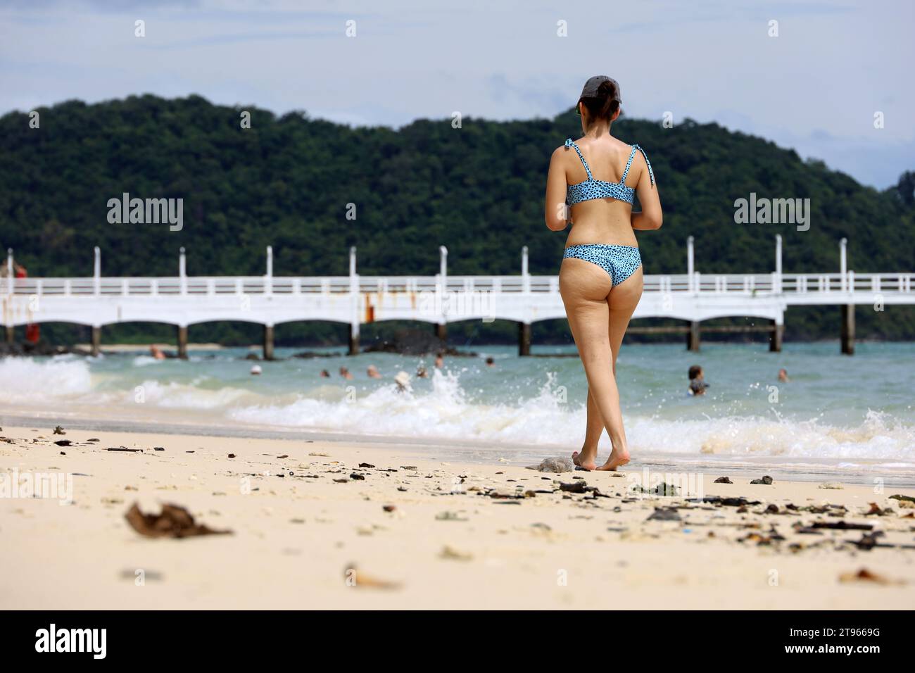 Schlanke Frau im Bikini, die am tropischen Strand am Sand vorbeiläuft. Seeküste, Urlaub im Ferienort Stockfoto