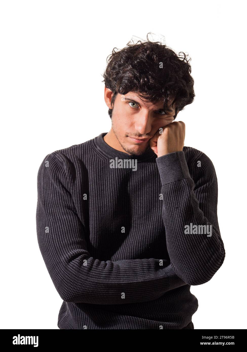 Ein Mann mit lockigen Haaren, der einen schwarzen Pullover trägt, denkt, enttäuscht oder traurig, im Studio, der in die Kamera schaut Stockfoto